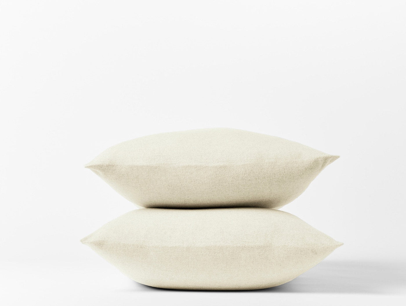 Two stacked ivory Coyuchi Cloud Brushed Flannel pillowcases against a white background.