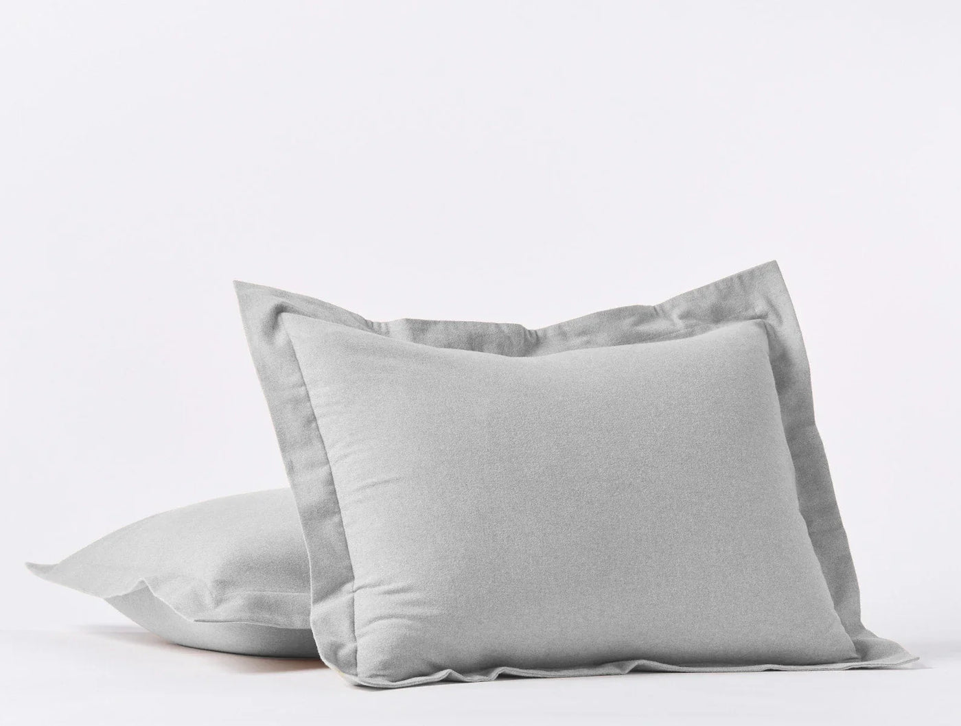 Close-up of two silver Coyuchi Cloud Brushed Flannel pillow shams with flange trim.