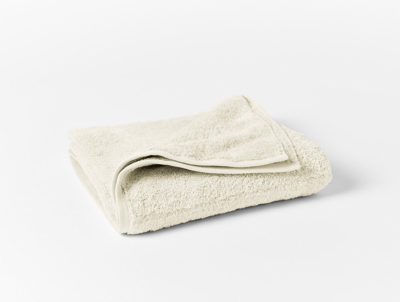 Coyuchi Cloud Loom bath towel folded, showing ivory terry texture and hemmed edge.