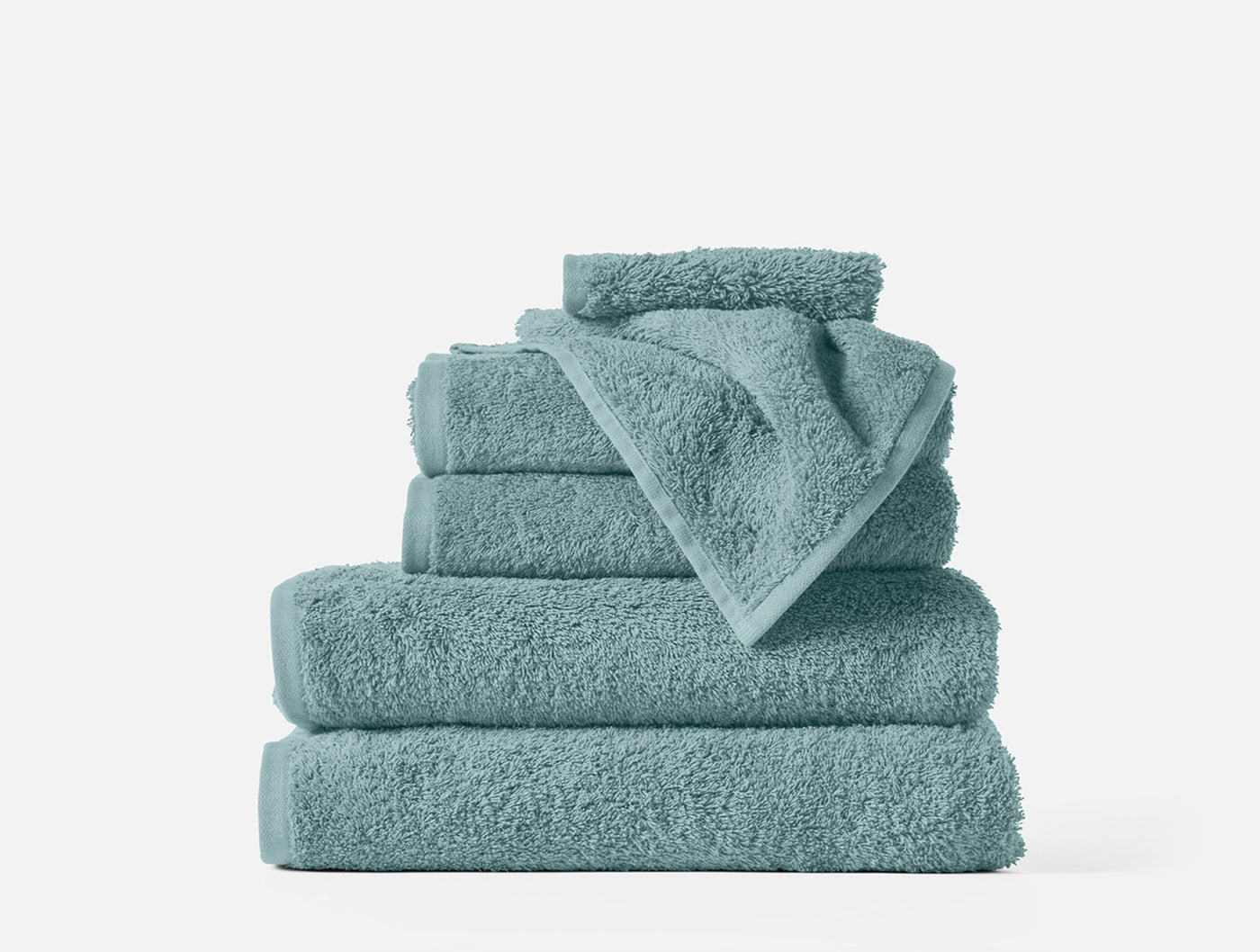Stacked set of Coyuchi Cloud Loom towels in seafoam, showing varied sizes neatly arranged.