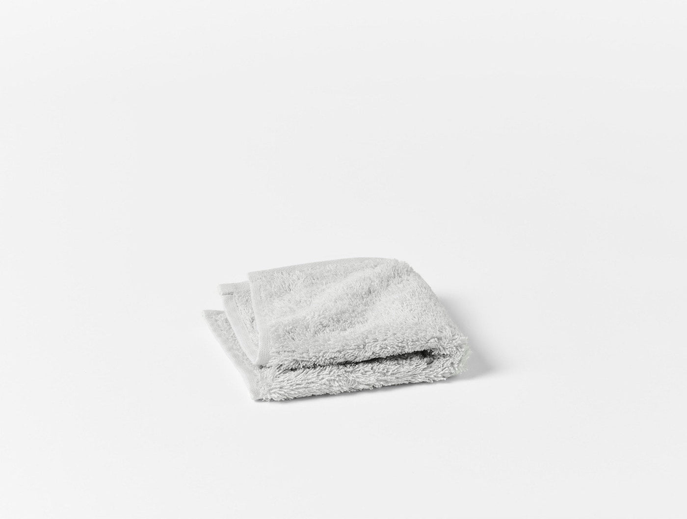 Coyuchi Cloud Loom face cloth folded flat, silver grey terry, top-down angle.