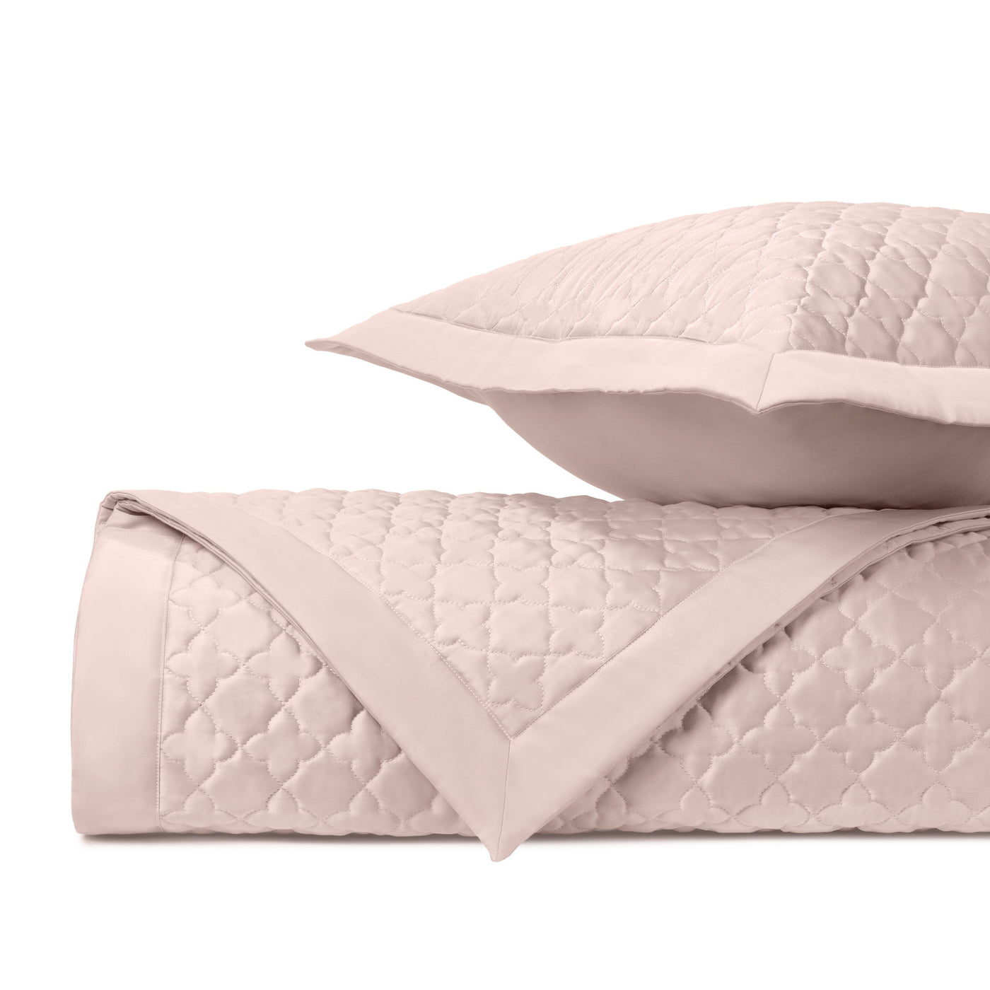 Close-up of blush quilted clover-pattern fabric with flat border detail.
