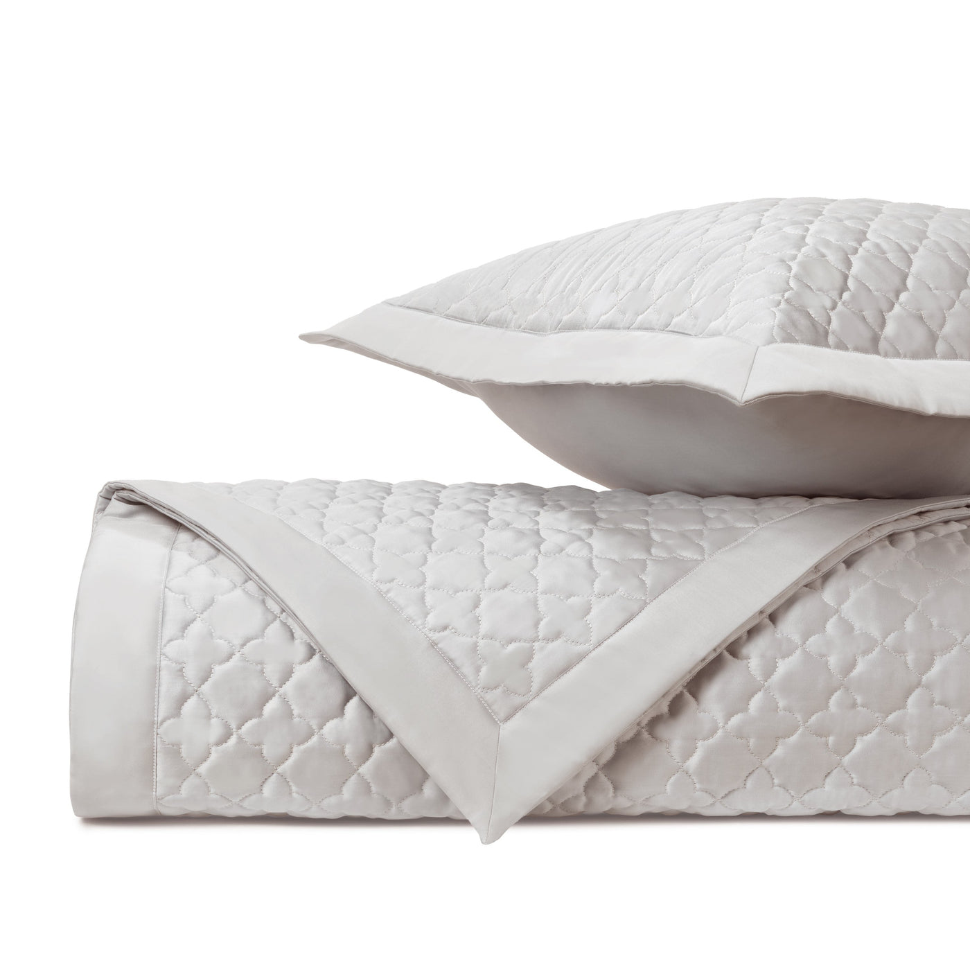 Close-up of Home Treasures Clover quilted texture in ivory with satin border trim.