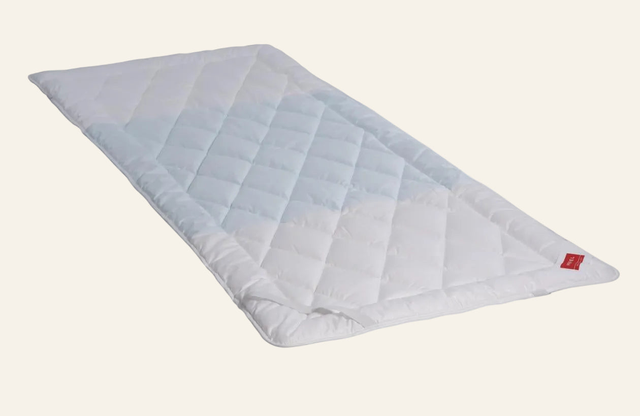 White quilt with geometric pattern on a white background