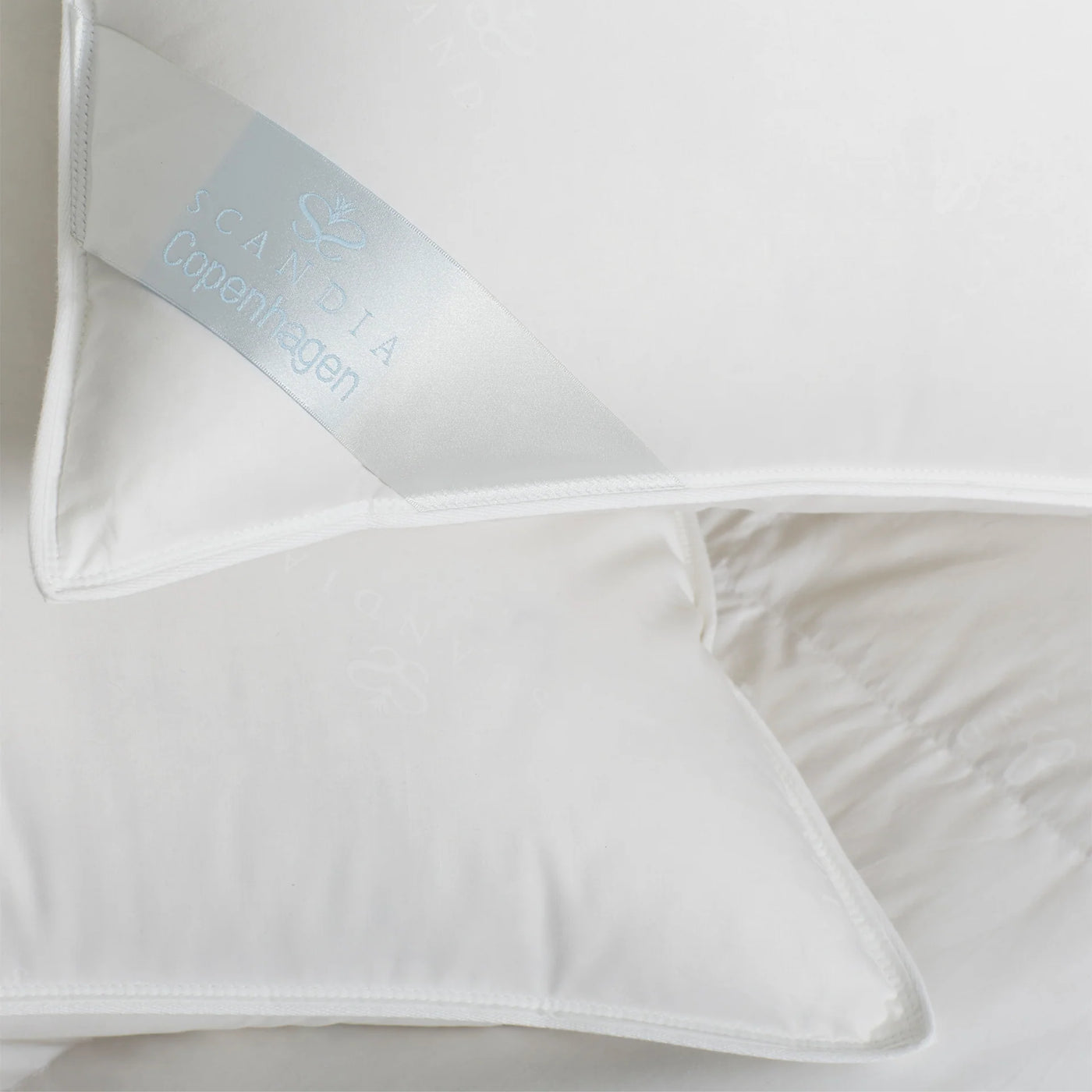 Close-up of Scandia Home Copenhagen duvet interior fill and pale blue embroidered label.