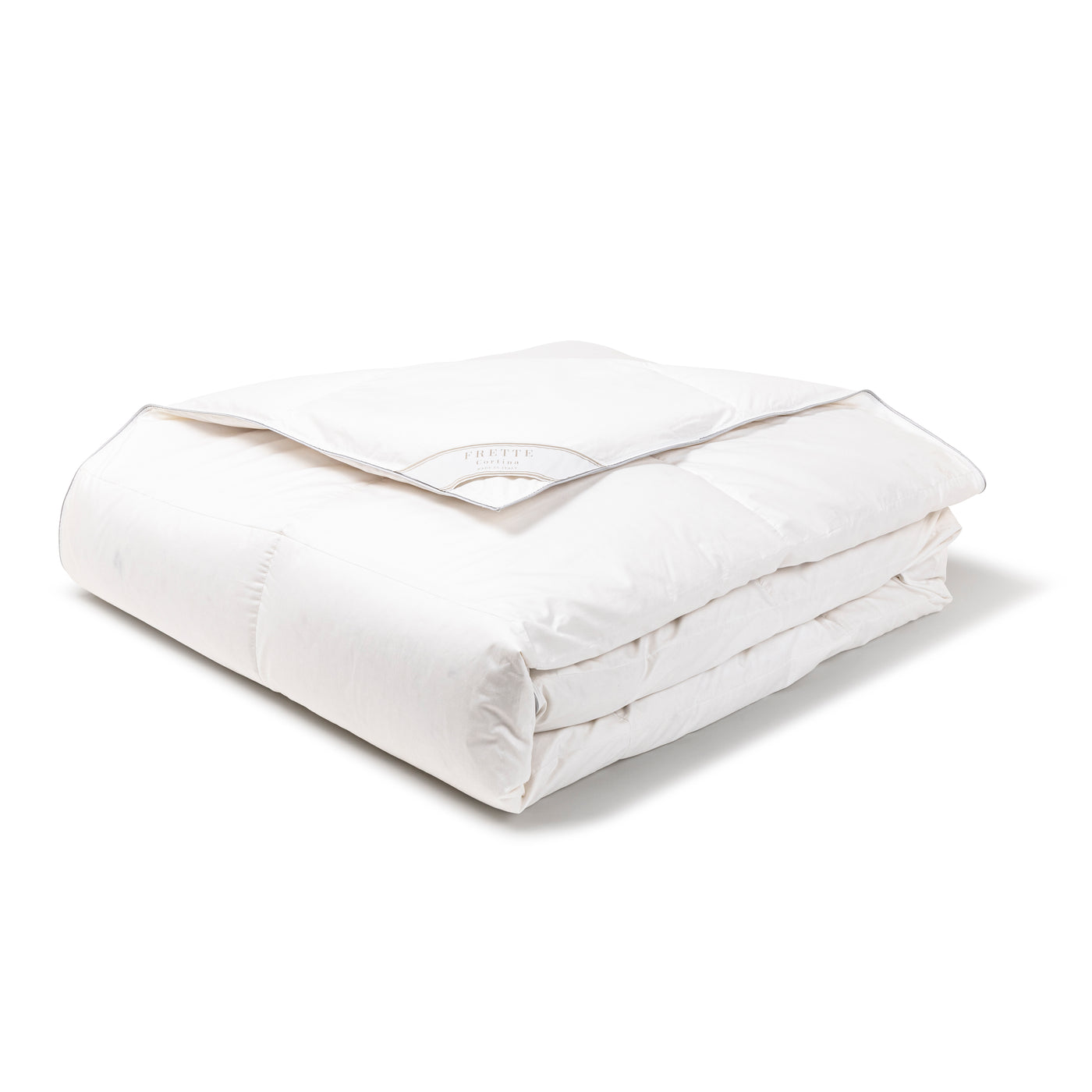 The Frette Cortina | Down Duvet Insert is a thick, white, folded comforter with a stitched border and small label on top, crafted with premium Polish goose down, shown on a plain white surface.