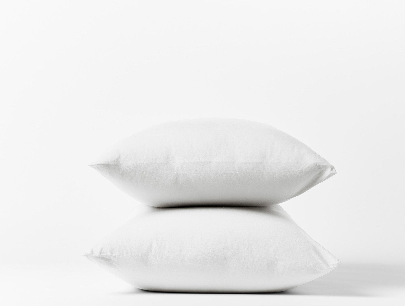 Coyuchi Crinkled Percale pillowcase pair in white, two pillows stacked against white background.