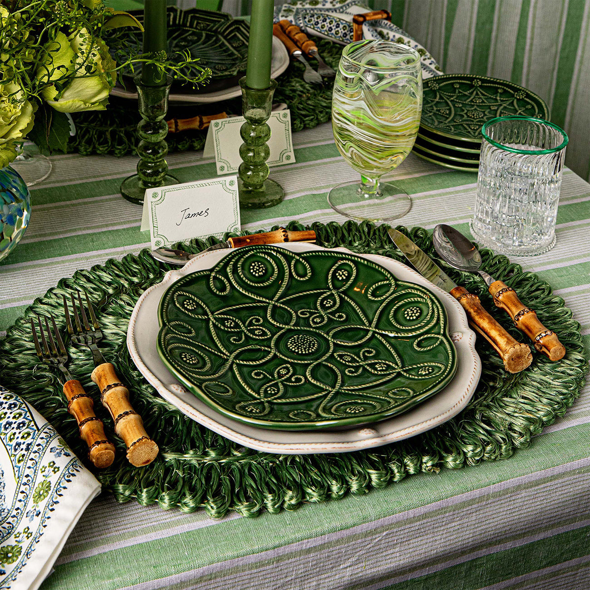 Berry & Thread place card above a green place setting on a woven charger