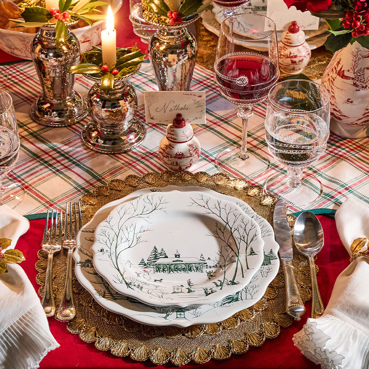 Evergreen Winter Frolic plates on a gold charger with a candle and plaid tablecloth