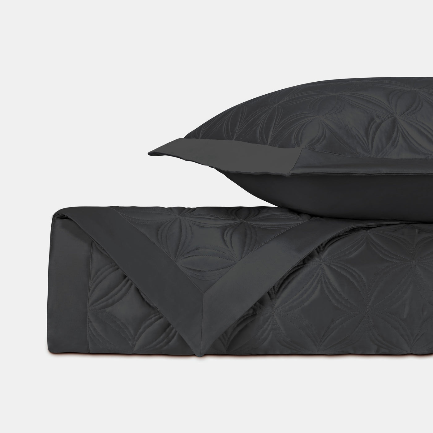 Close-up of Home Treasures Dara quilted coverlet in onyx with floral medallion stitching.