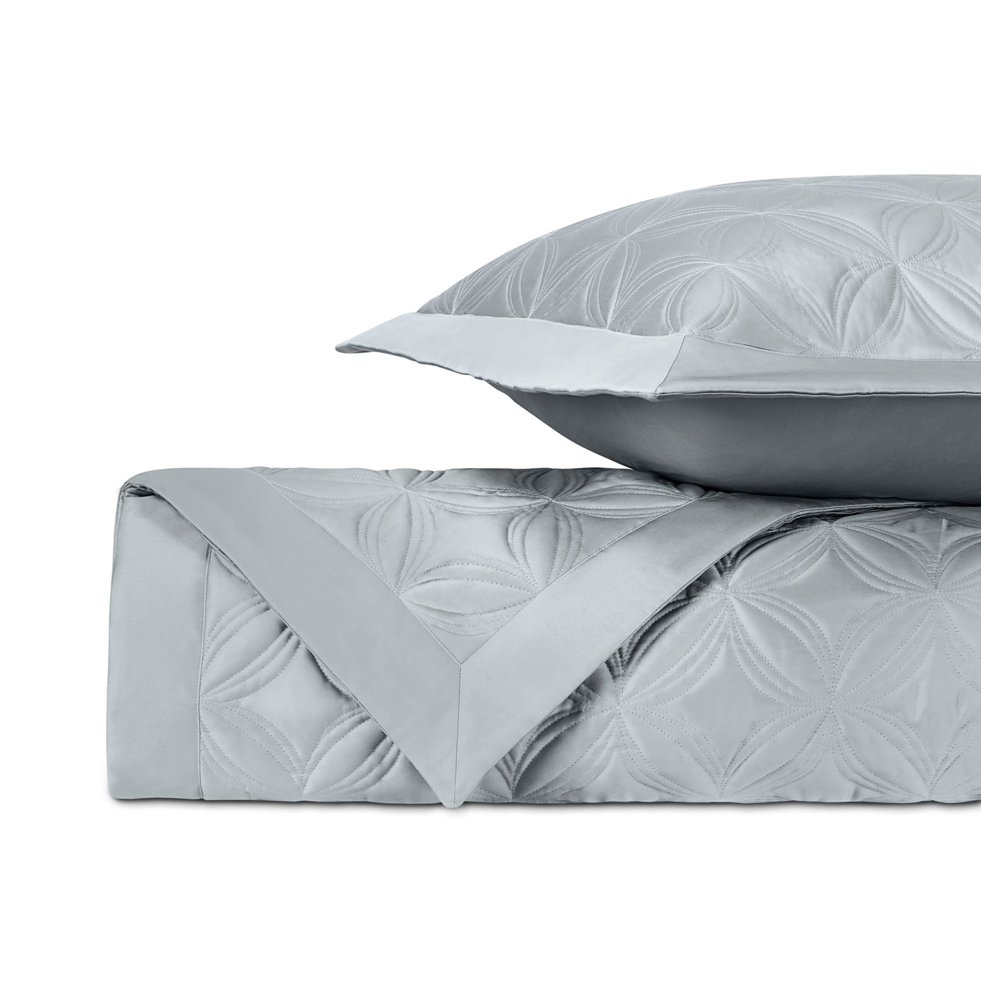 Folded silver quilted coverlet with geometric floral pattern, paired with matching euro sham.