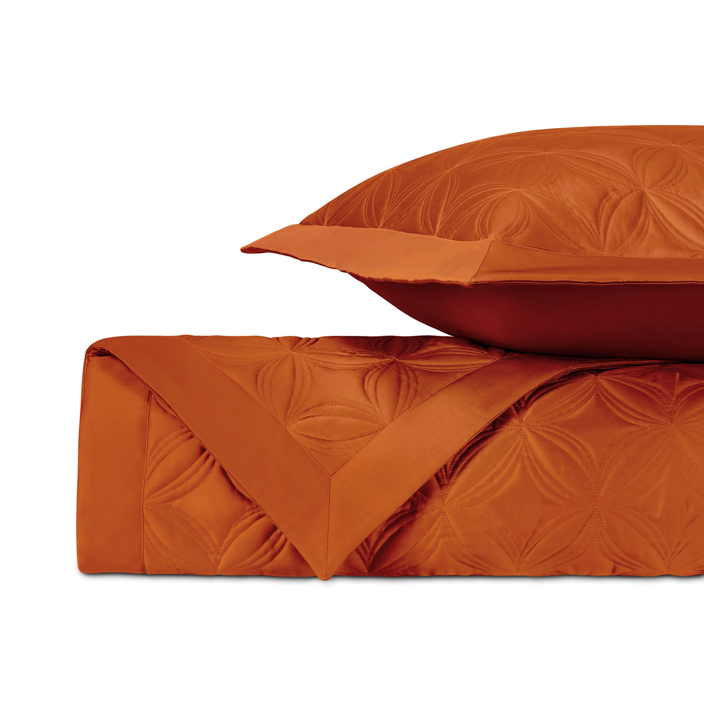 Close-up of tangerine quilted floral pattern on Dara coverlet with matching sham.
