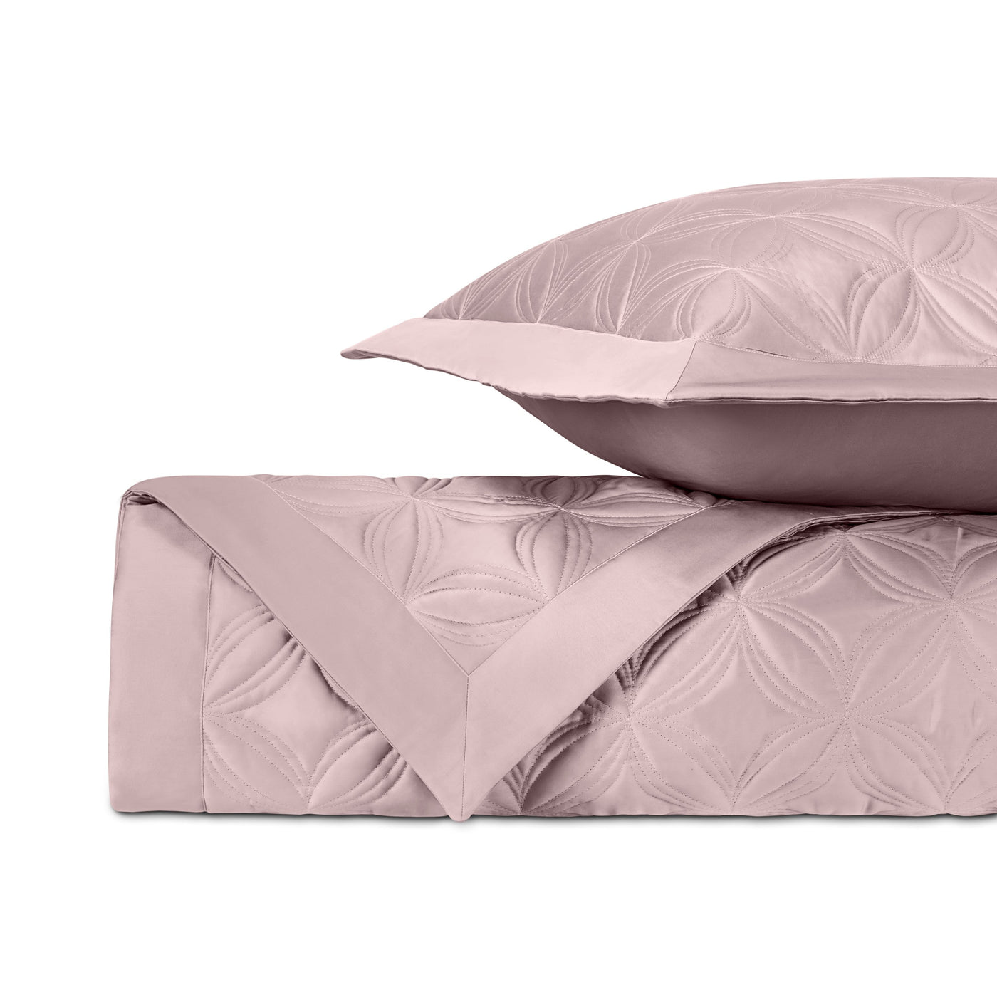 Close-up of blush quilted cotton with embossed floral medallion pattern.