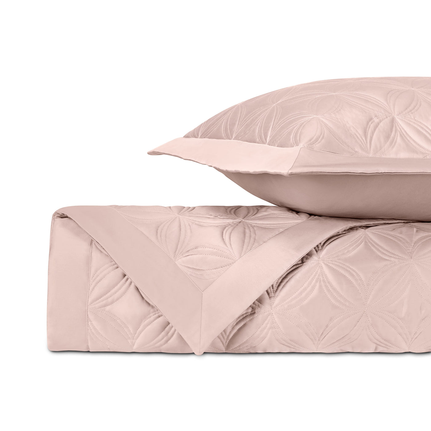 Close-up of blush Dara quilted coverlet showing embossed floral medallion pattern and sham.