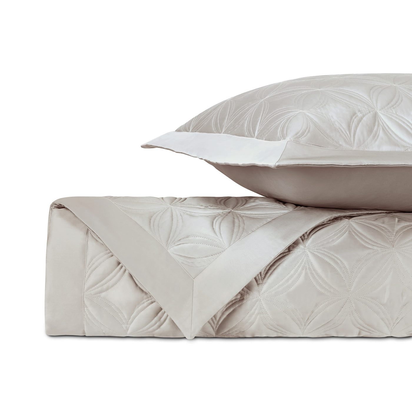 Close-up of Home Treasures Dara quilted satin in champagne with geometric floral stitching.