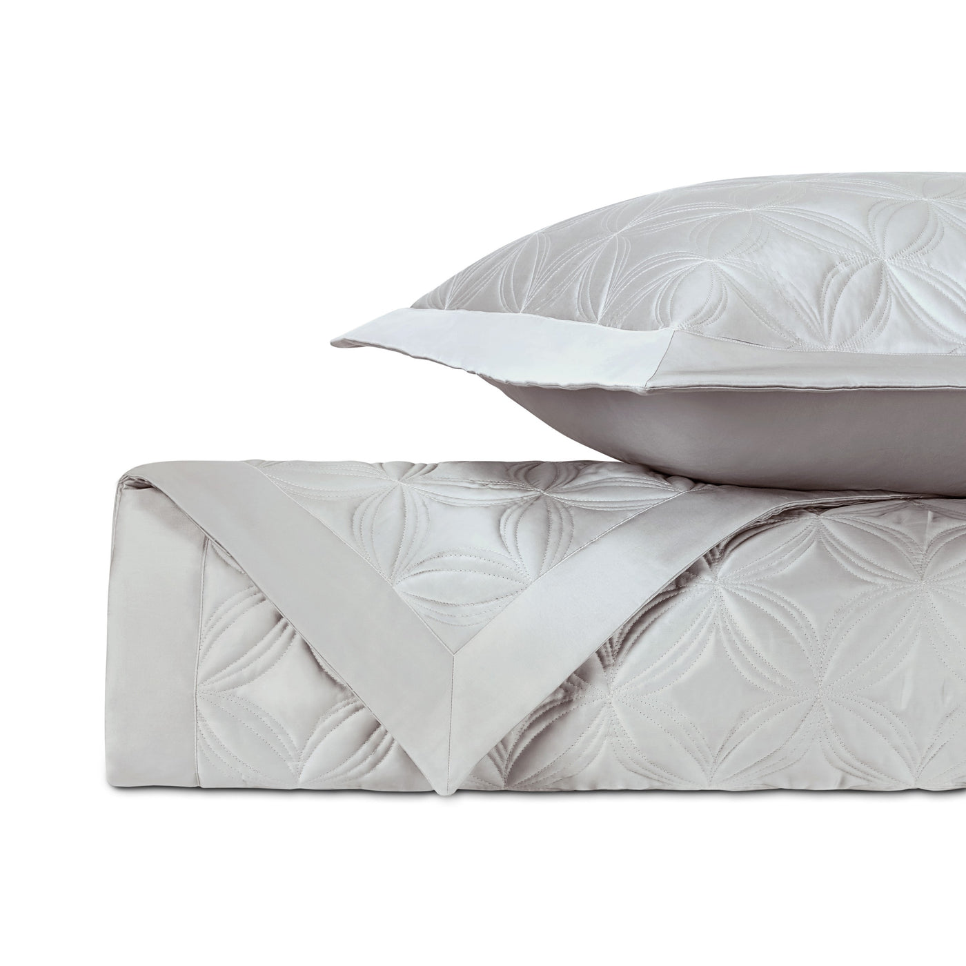 Close-up of Dara quilted satin in silver-grey, showing geometric petal pattern texture.