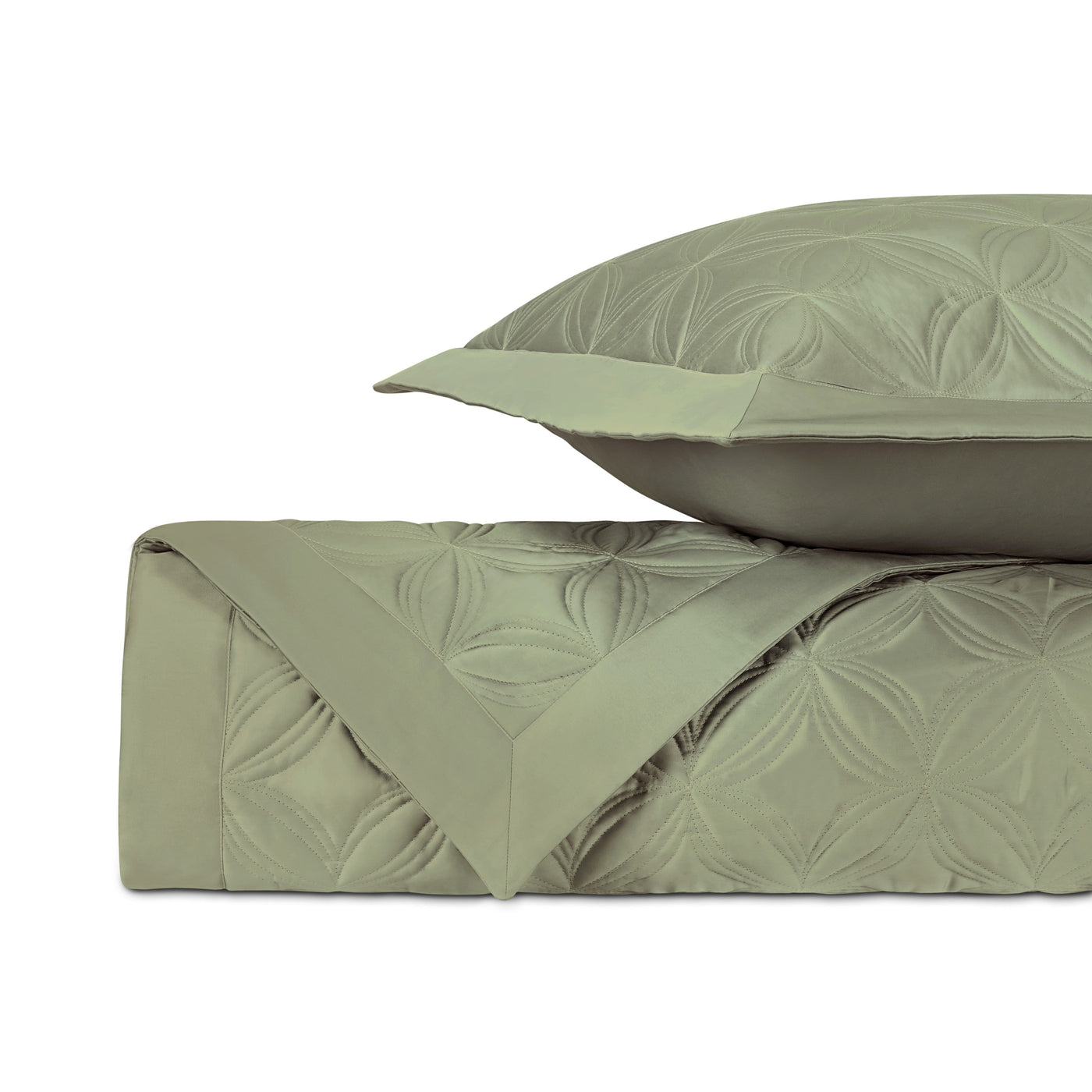 Close-up of sage green quilted coverlet showing embossed floral medallion pattern.