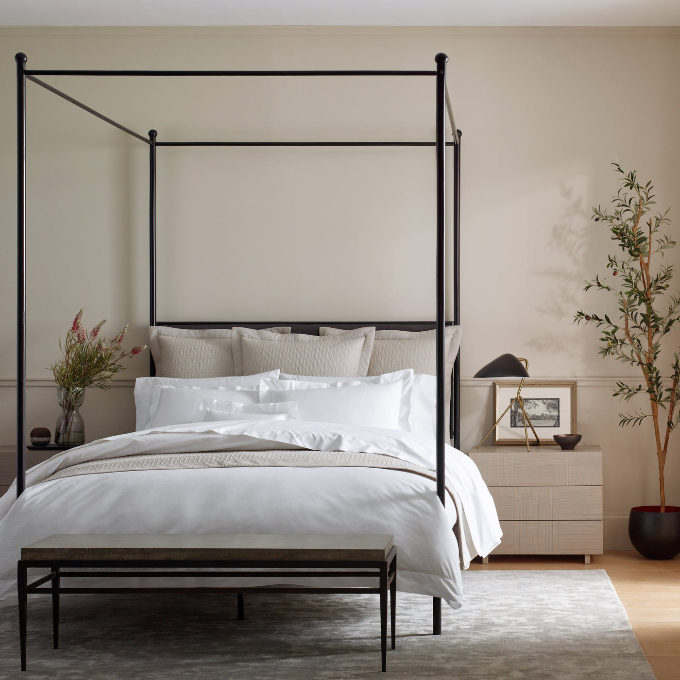 Home Treasures Darcy bedding in white on a black canopy bed with neutral layered pillows.