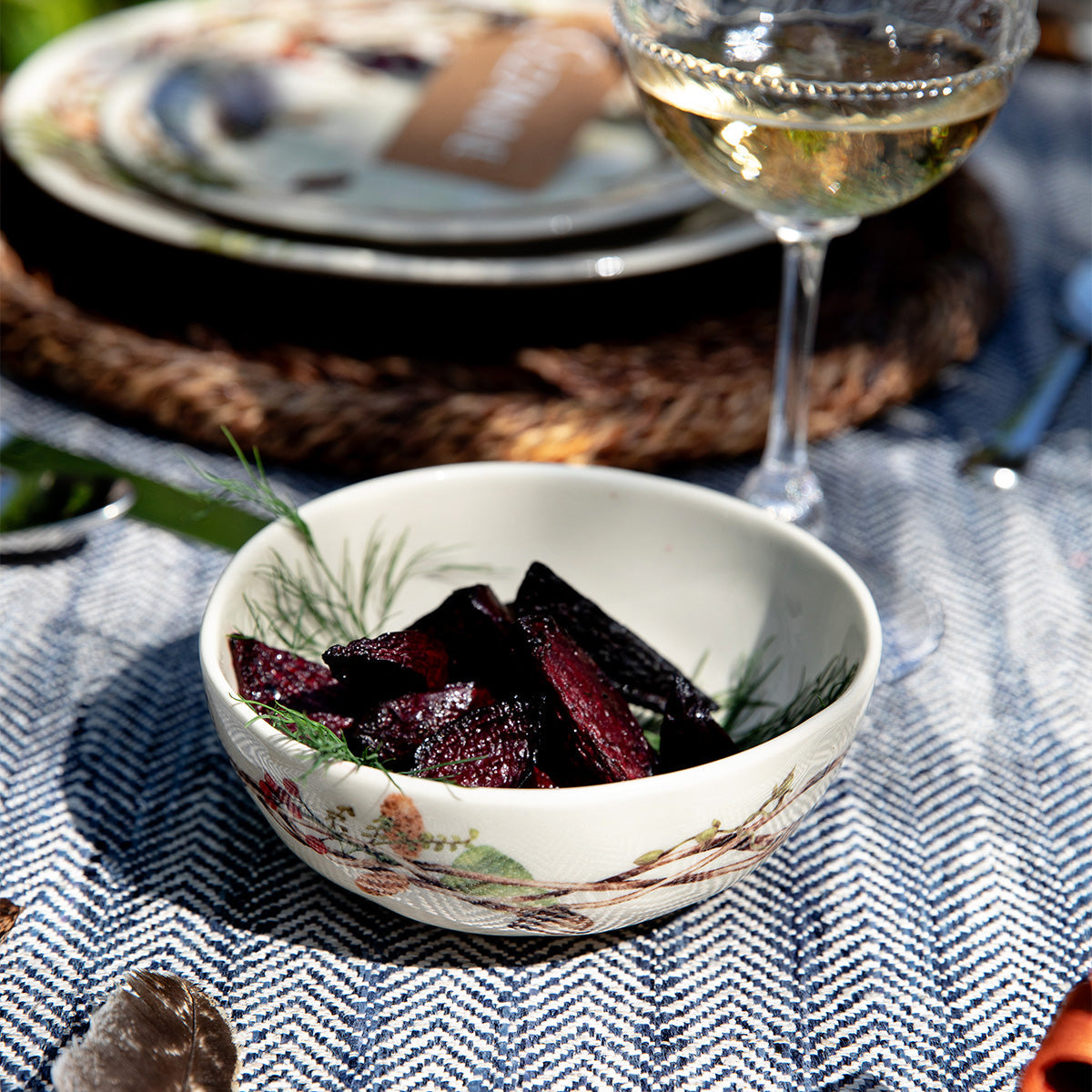 Forest Walk berry bowl holding sliced roasted beets on a blue herringbone cloth