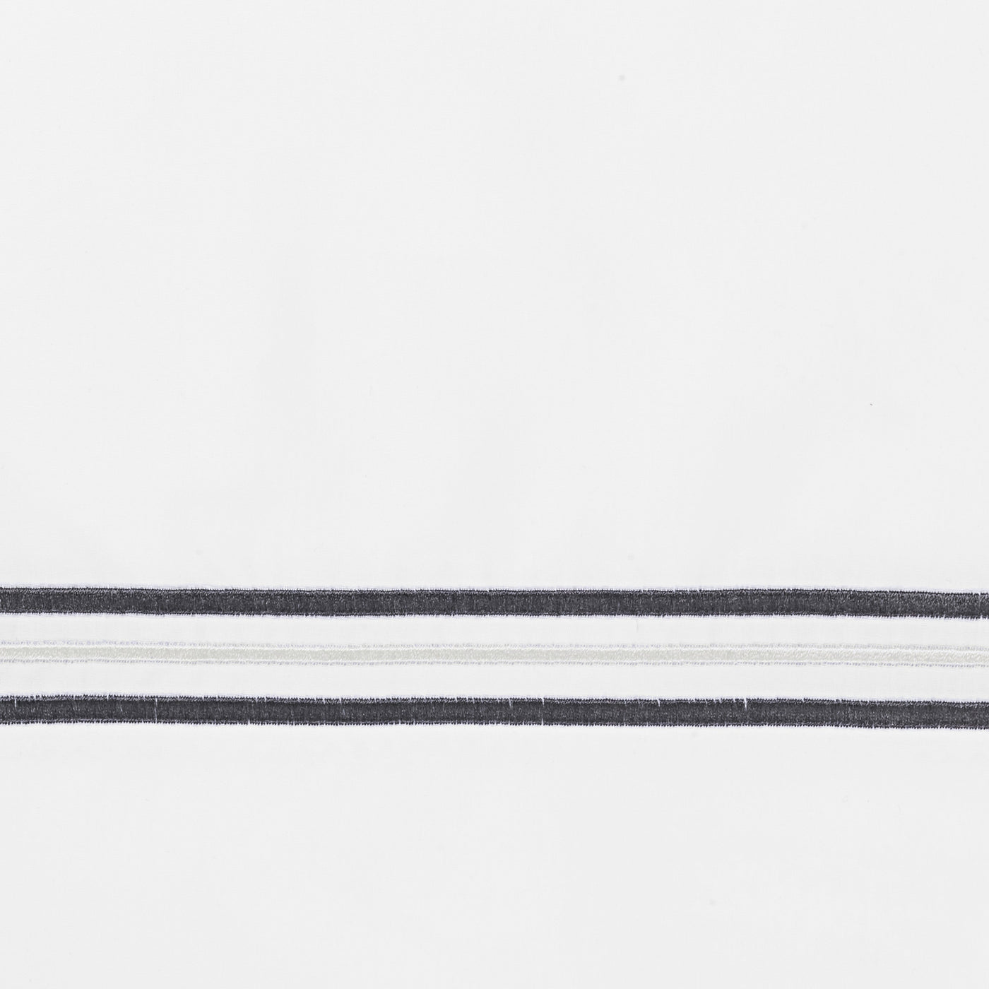 Close-up of Home Treasures Delancey charcoal stripe embroidery on white cotton.