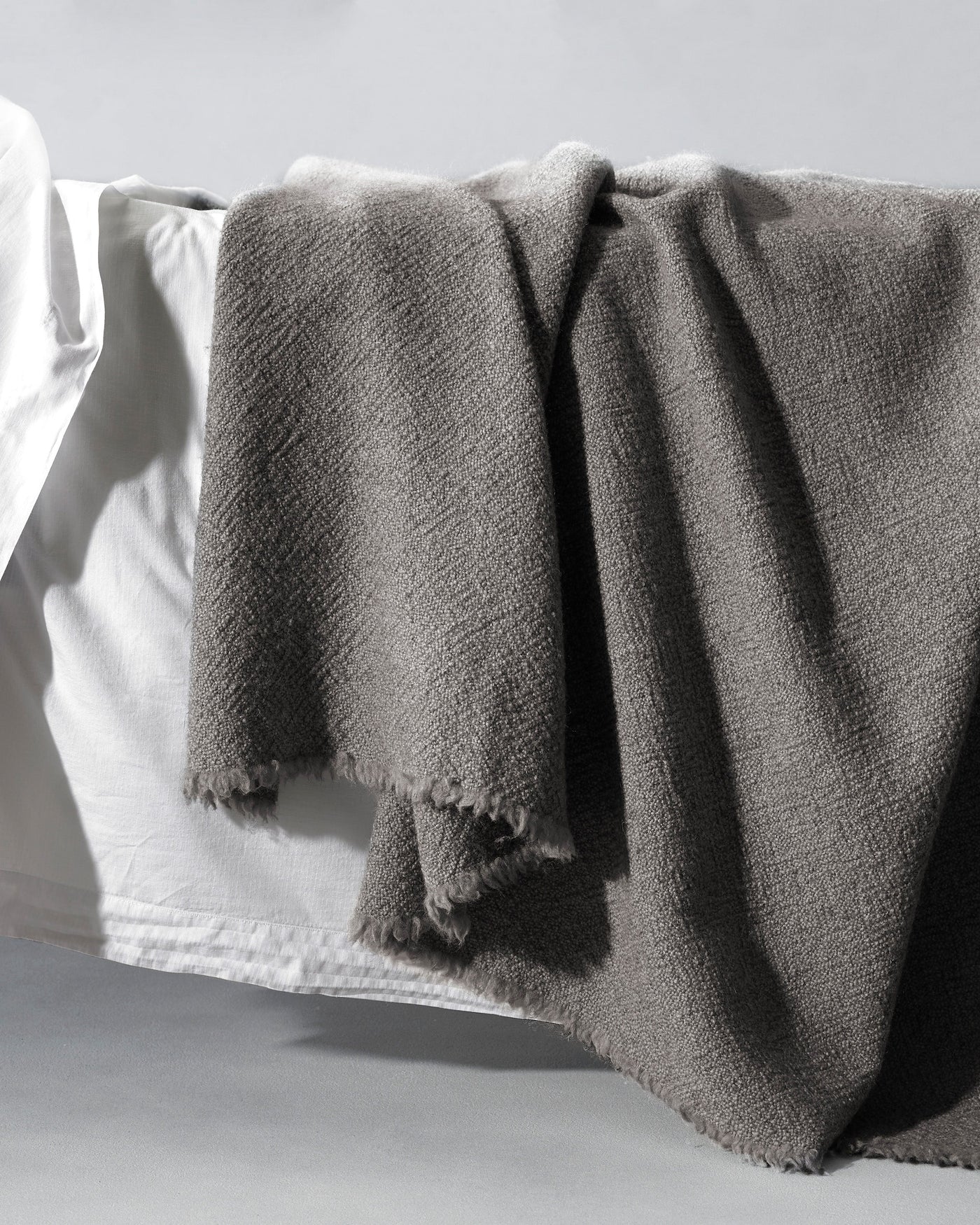 Fringed edge detail of the Society Limonta Des blanket in slate grey.