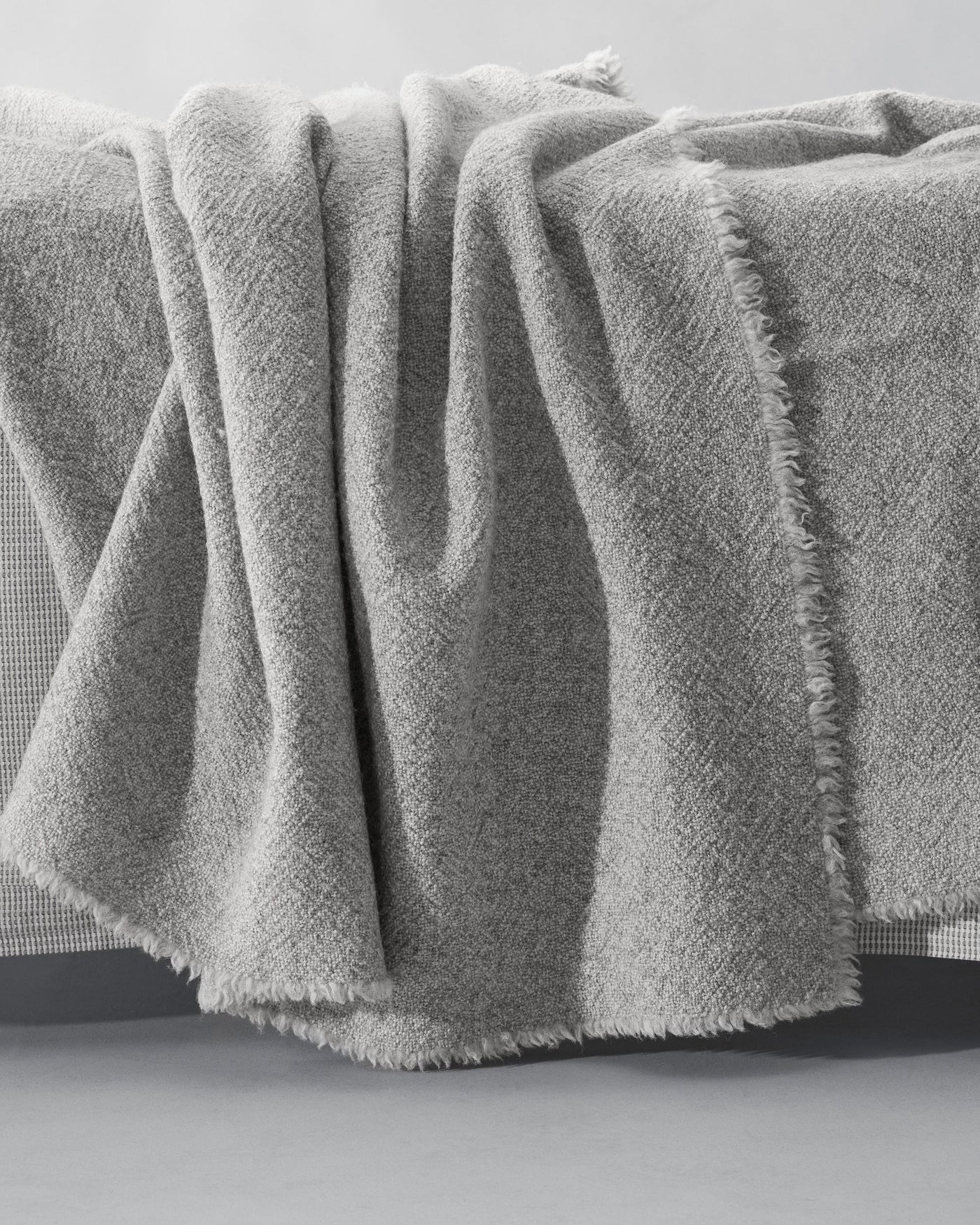 Society Limonta Des blanket in silver-grey textured wool with fringe trim, draped softly.