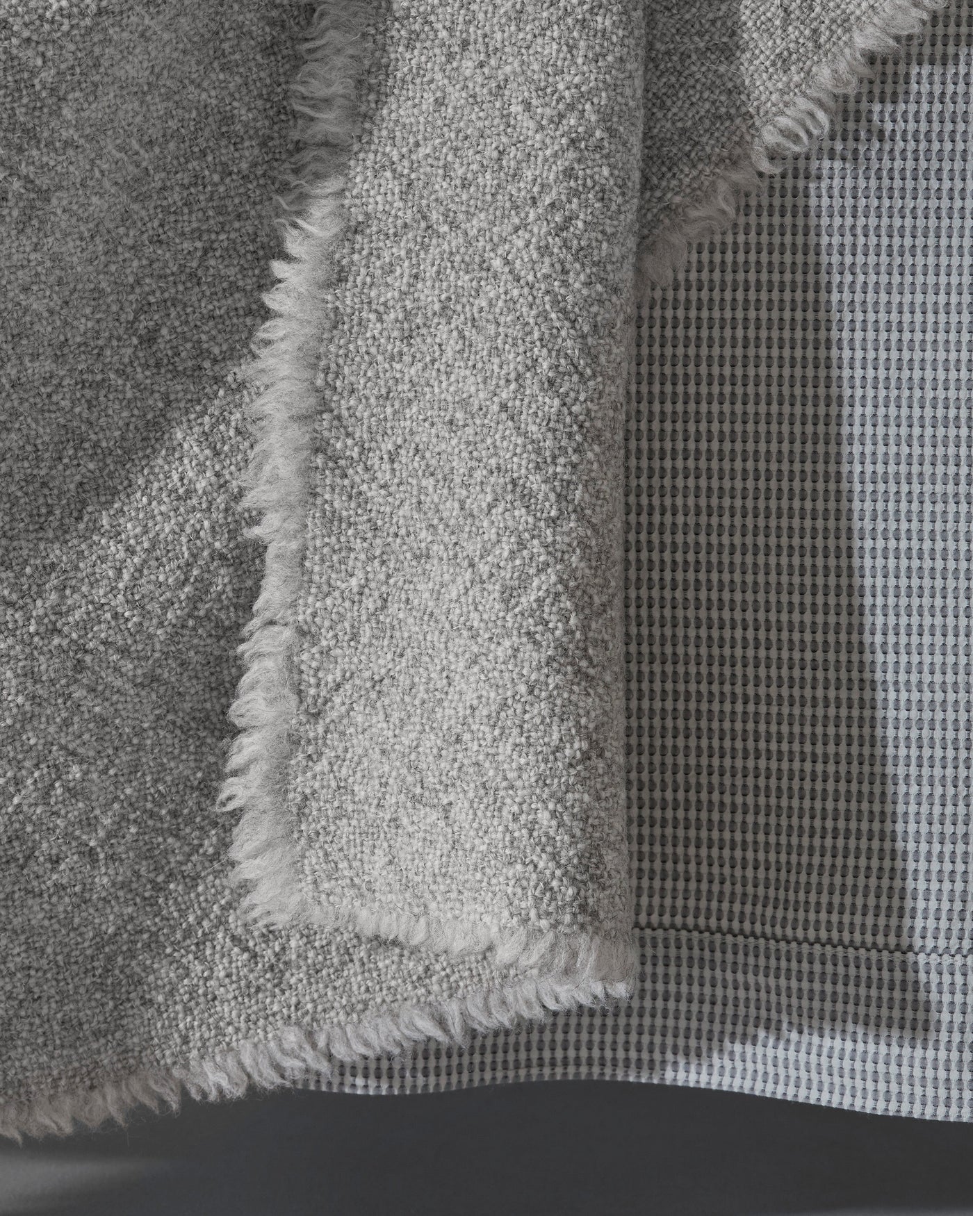 Close-up of Society Limonta Des blanket showing fringe edge and dual-texture weave in dove grey.