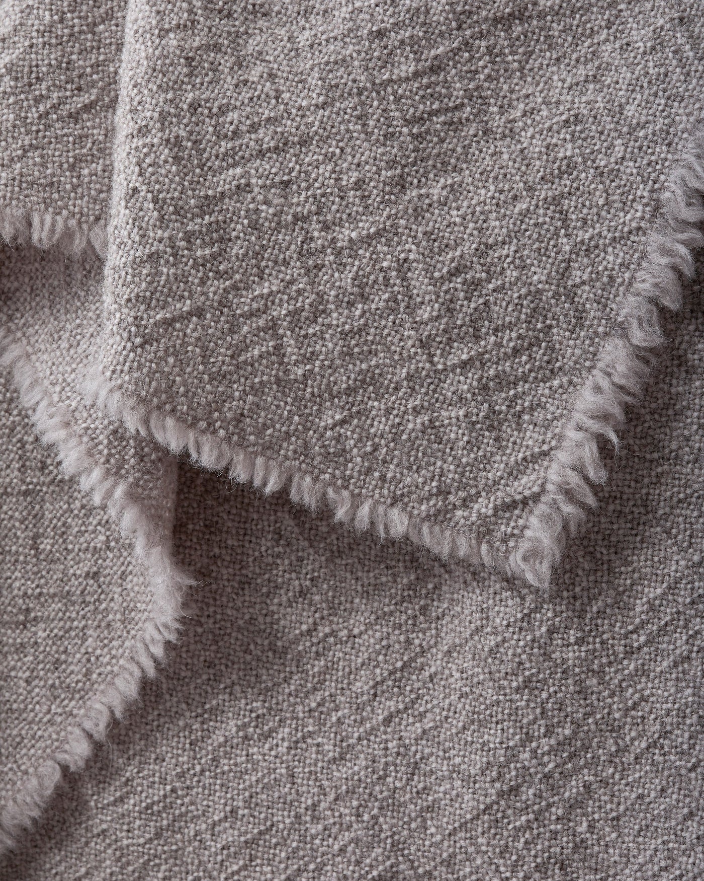 Close-up of fringe edge detail on Society Limonta Des blanket in heathered greige.
