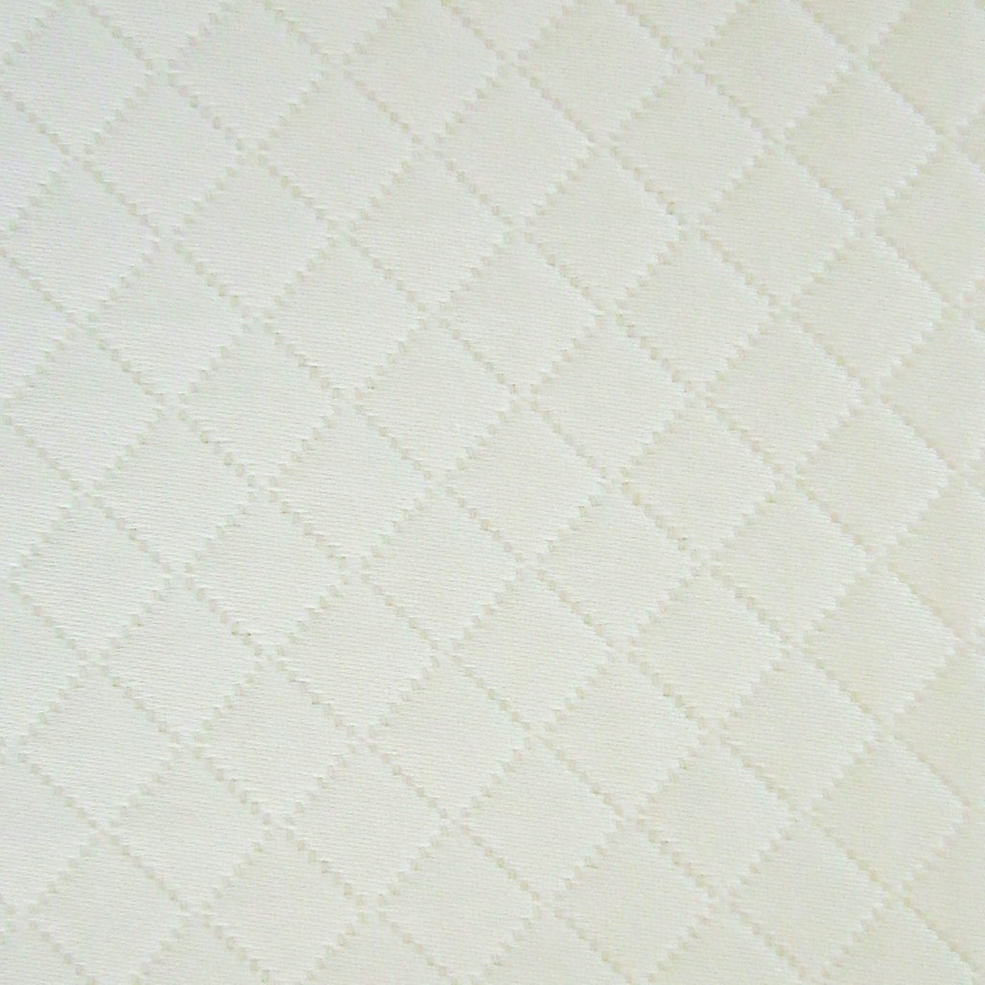 Close-up of ivory cotton fabric with woven diamond quilted pattern.