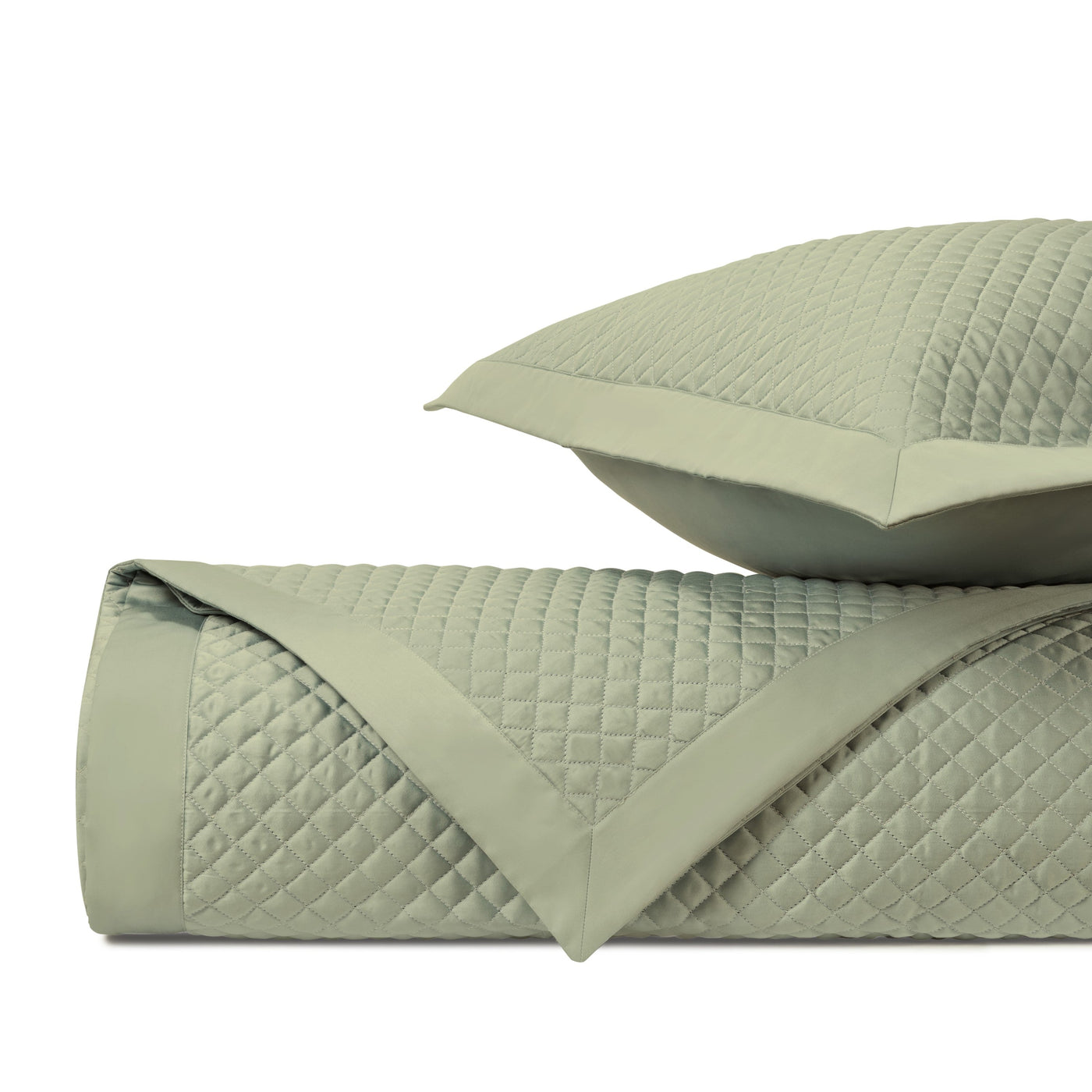 Close-up of sage green diamond-quilted texture with contrast border detail.