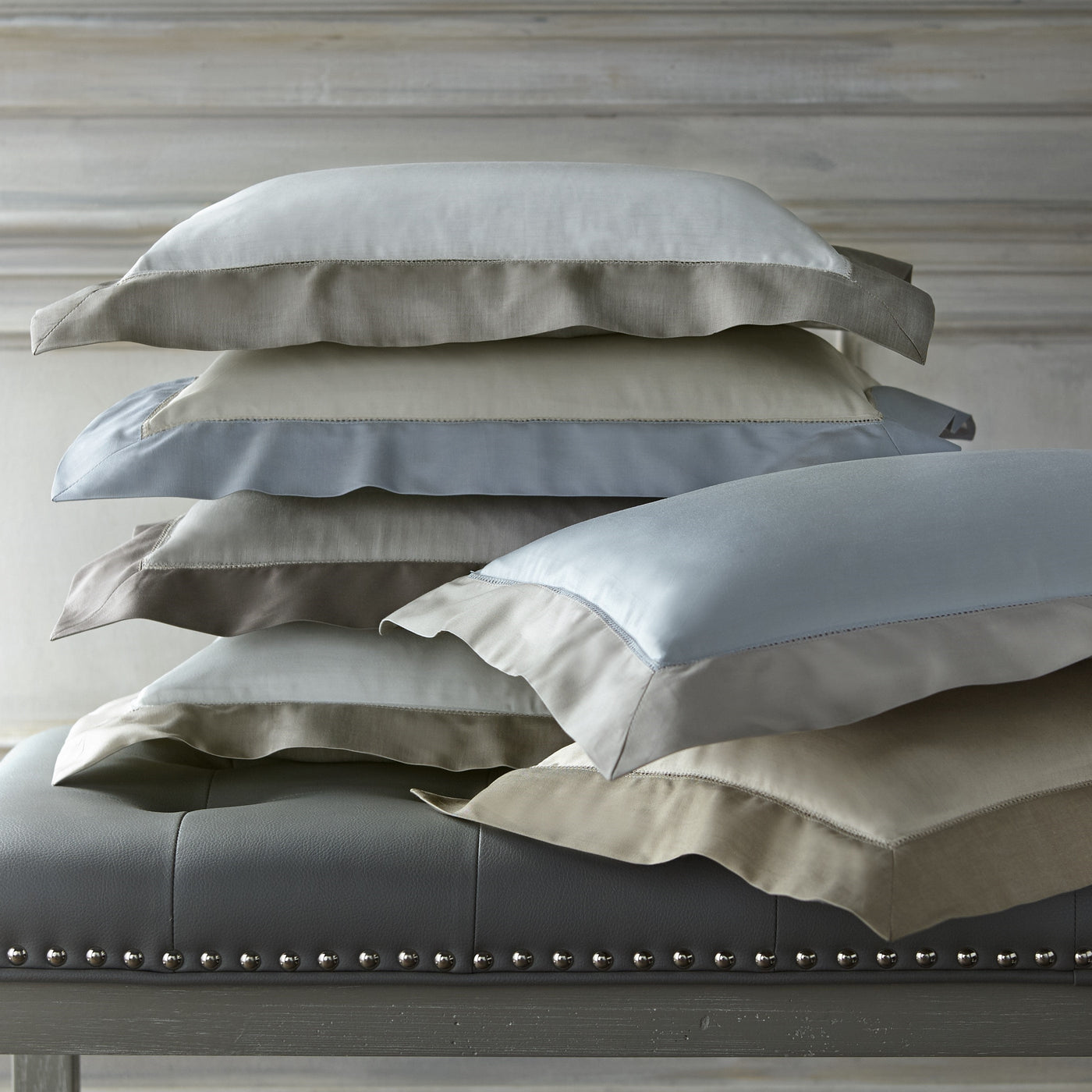 Home Treasures Doppio pillowcases stacked in silver, dove, taupe, and champagne sateen.