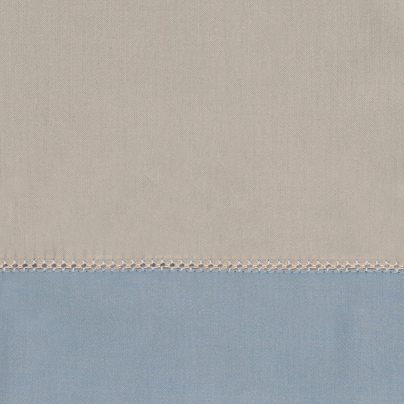 Close-up of sand and powder blue linen yardage with a delicate hemstitch border detail.
