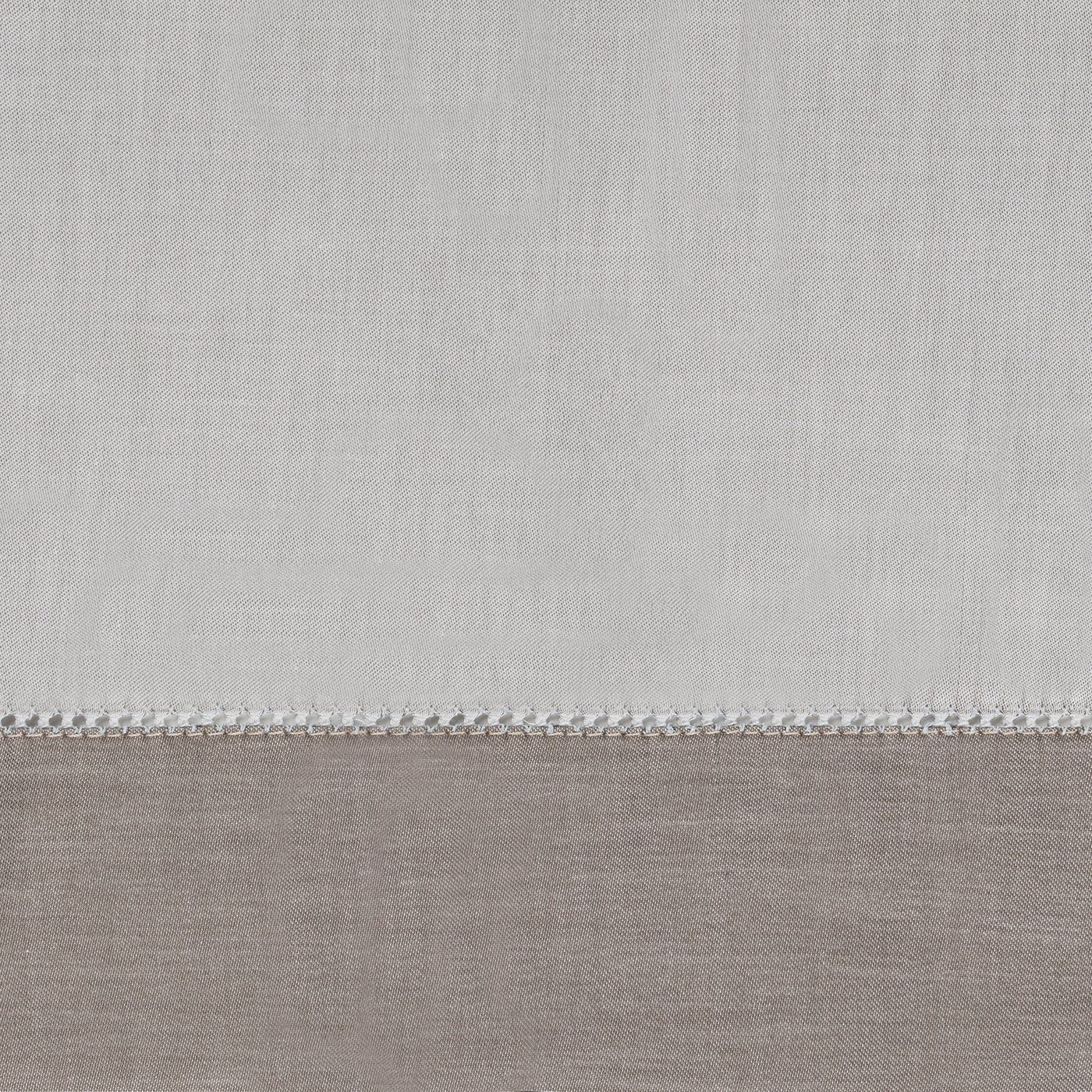 Close-up of ivory and taupe linen yardage with delicate crochet trim border detail.