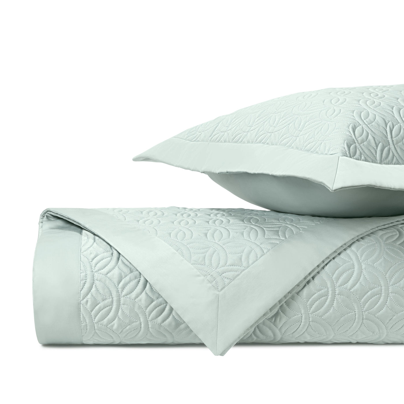 Close-up of Home Treasures Duomo quilted texture in mist green with geometric floral pattern.