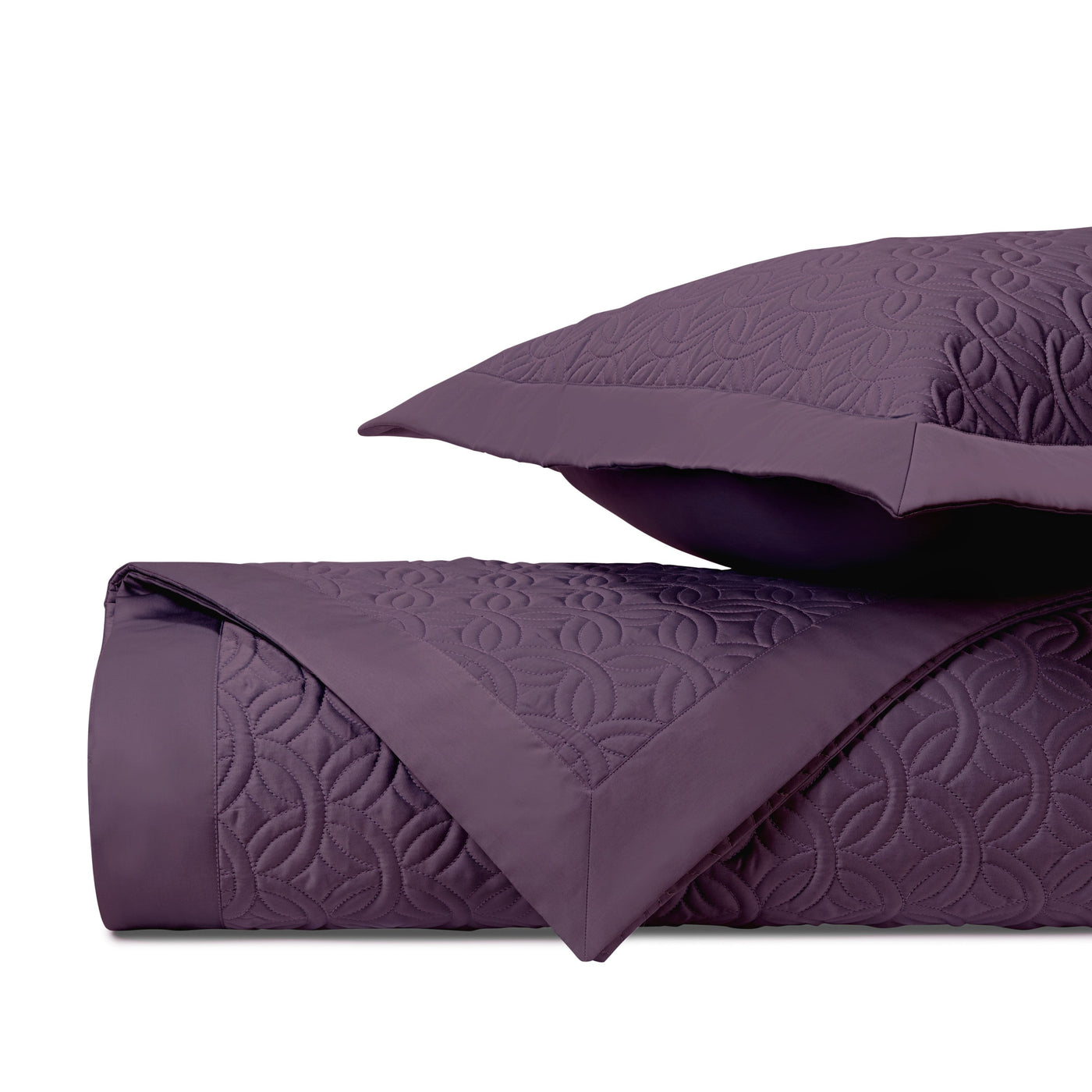 Close-up of Duomo quilted coverlet in plum with tone-on-tone geometric embroidery.
