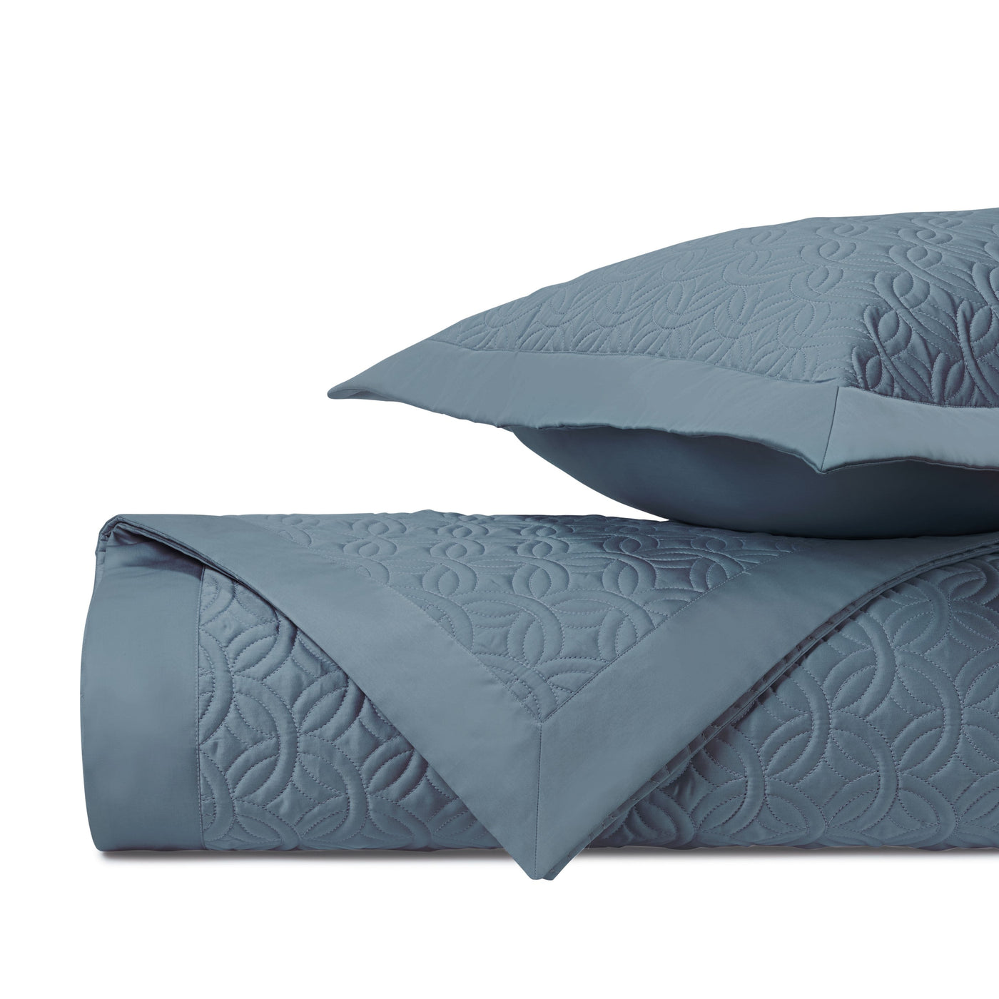 Close-up of Home Treasures Duomo quilted texture in slate blue with geometric motif detail.