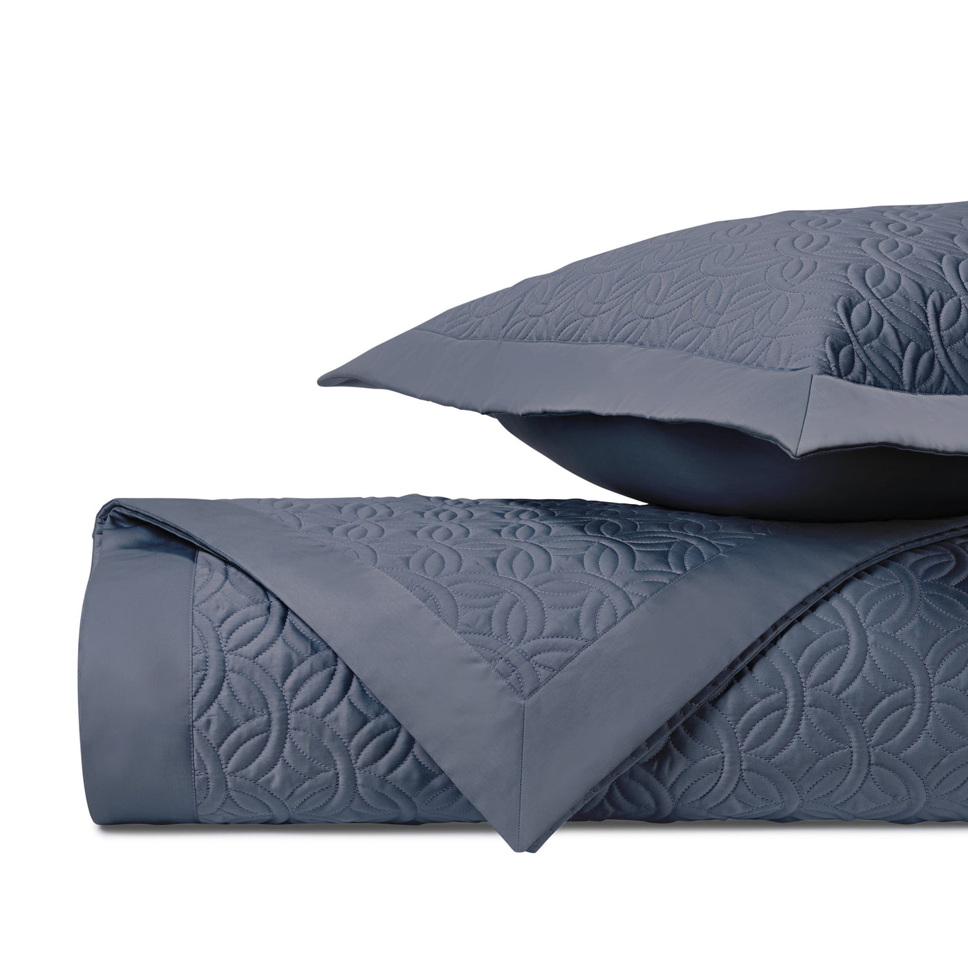 Close-up of Home Treasures Duomo quilted texture in slate blue with geometric floral pattern.