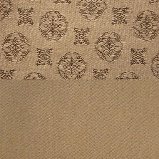 Close-up of camel jacquard medallion border against plain woven fabric.