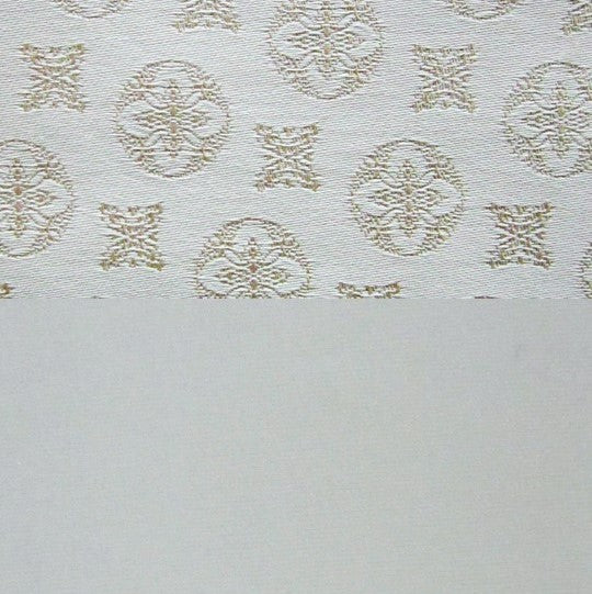 Close-up of ivory cotton pillow sham with champagne jacquard medallion pattern.