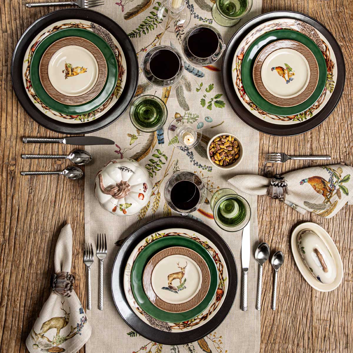 Overhead view of the Forest Walk table runner with place settings, green chargers and napkins