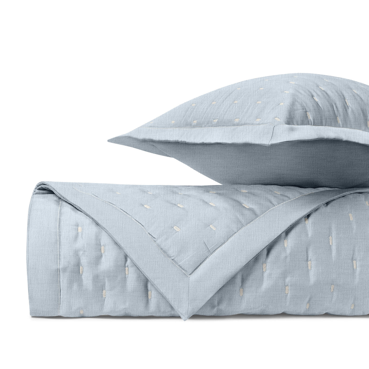 Folded Houston quilted coverlet in mist blue with ivory dash pattern and coordinating sham.