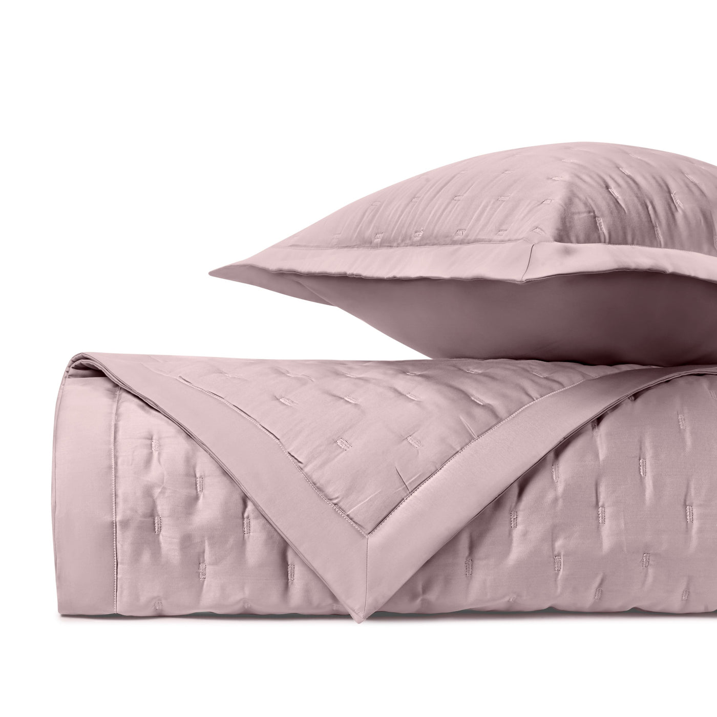 Blush fil coupé quilted texture close-up with coordinating sham and folded coverlet.