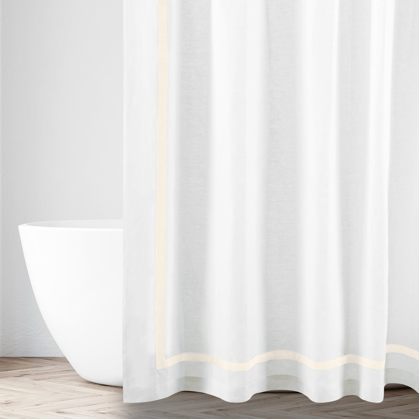 White linen shower curtain with champagne border trim, styled in a bathroom setting.