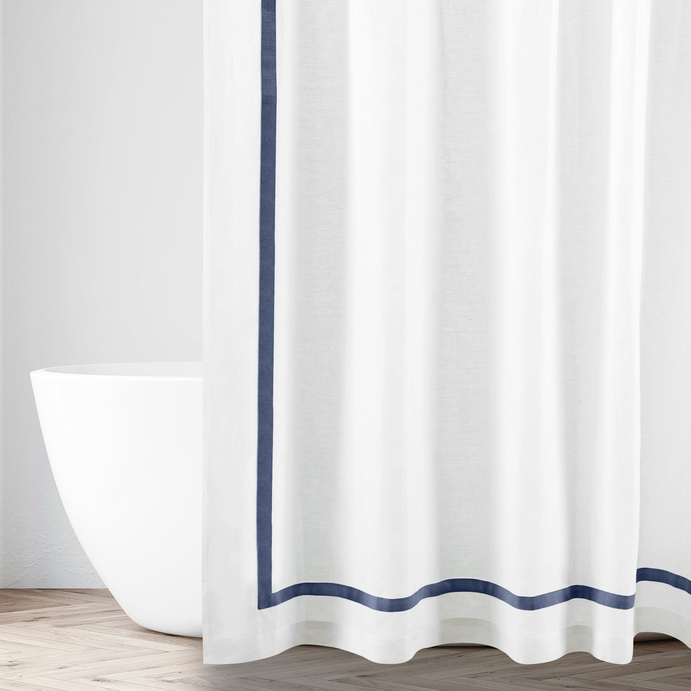White shower curtain with navy grosgrain ribbon border trim in a bathroom setting.