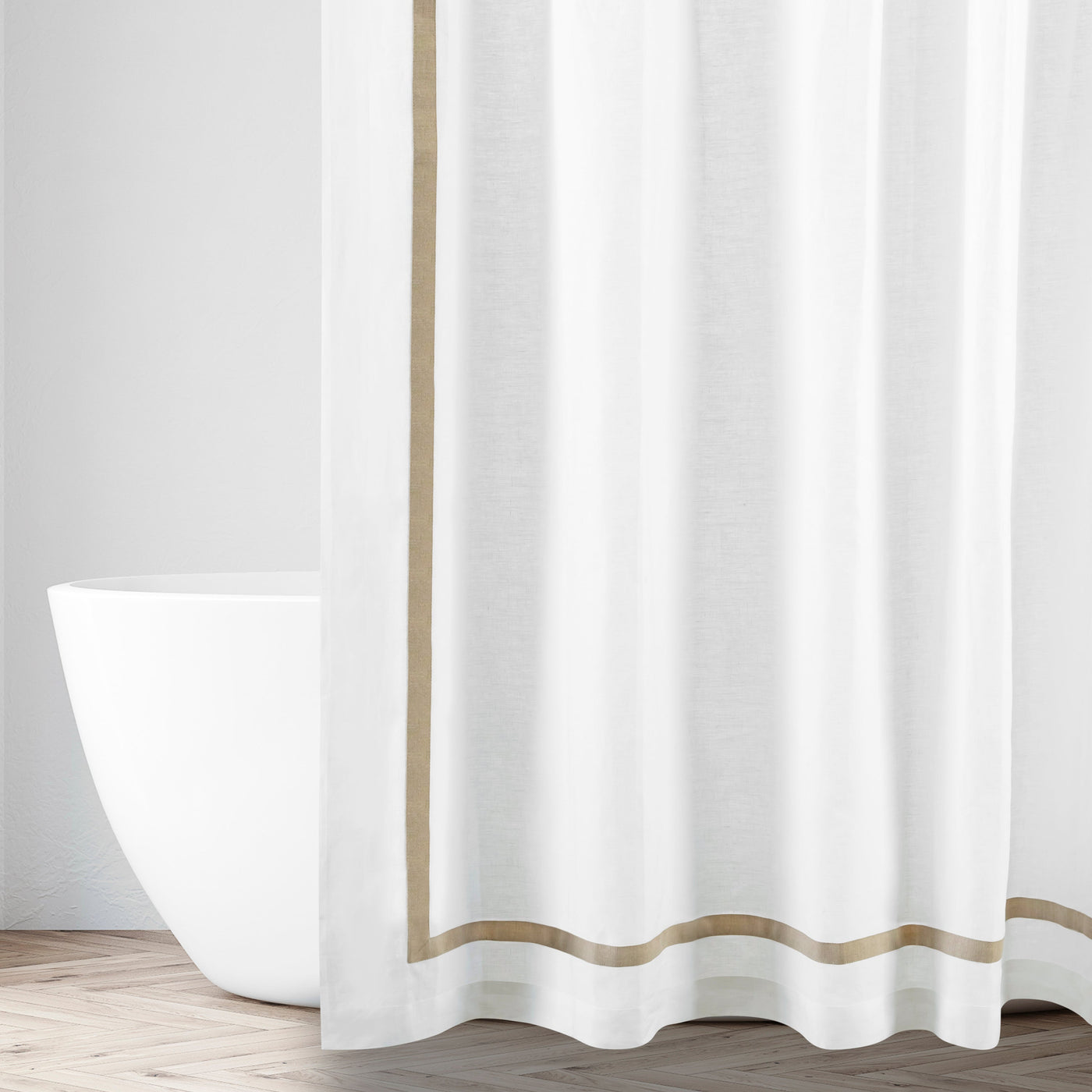 White linen shower curtain with champagne border trim, styled in a bright bathroom setting.