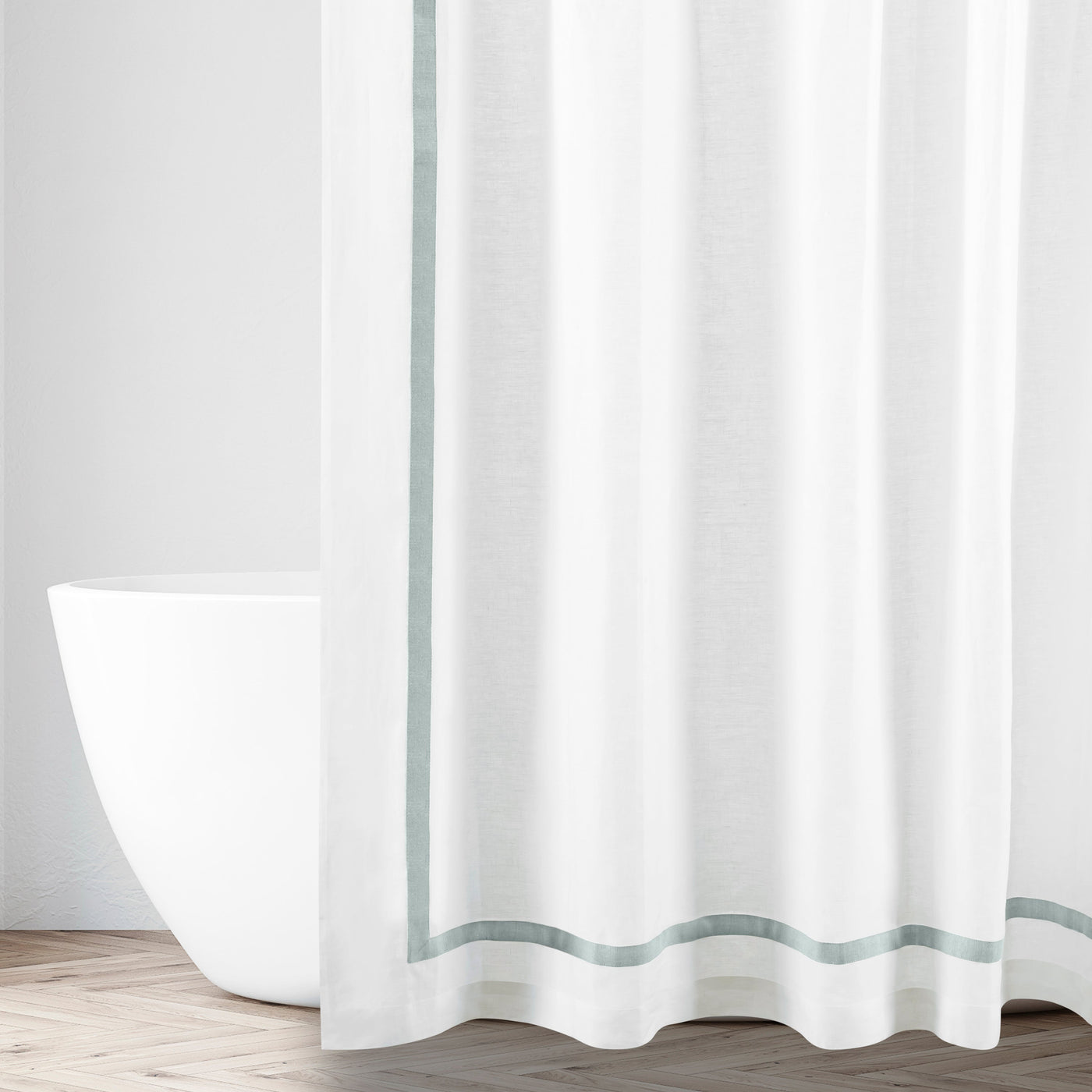 Sage double-stripe border detail on white linen shower curtain, freestanding tub visible.
