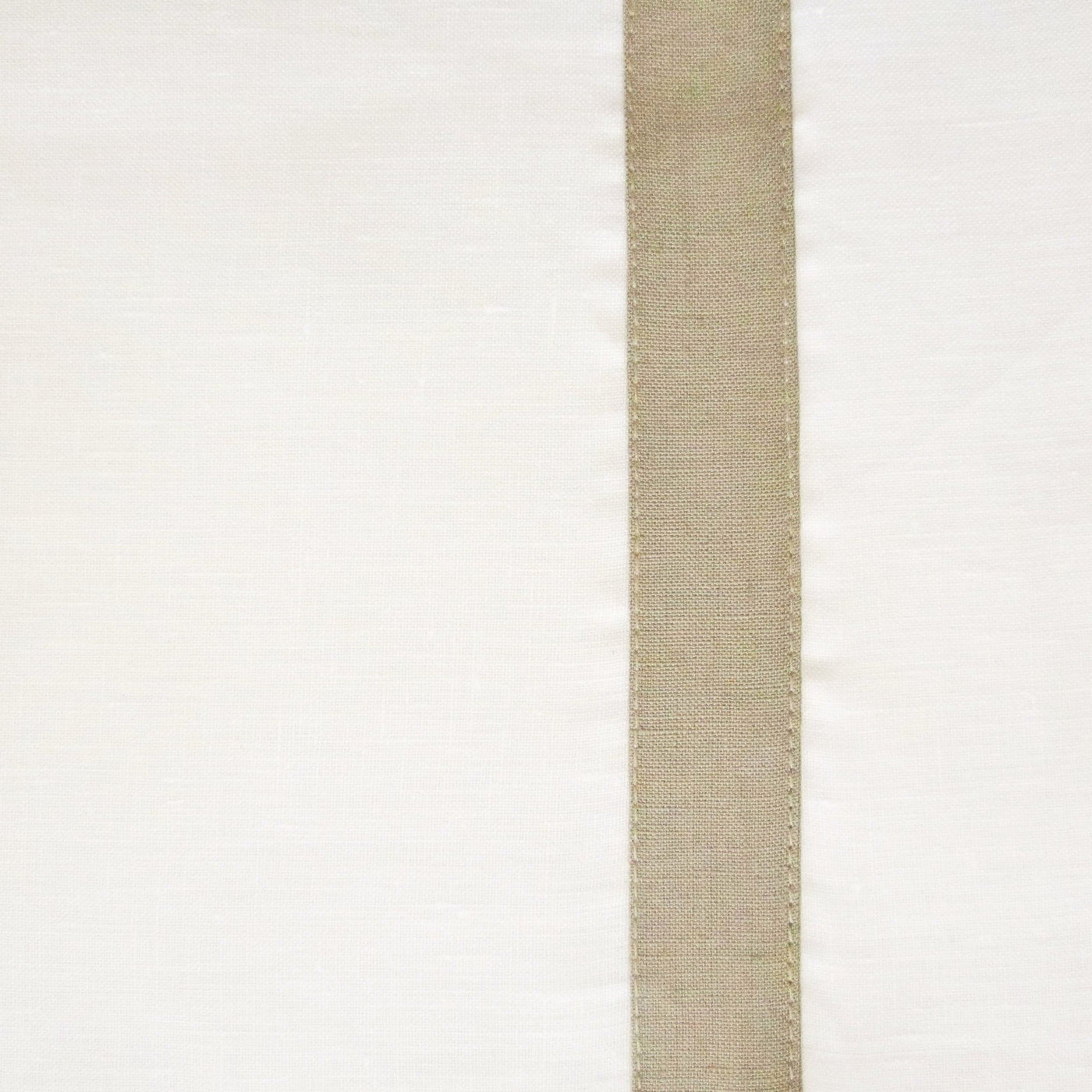 Close-up of ivory linen placemat with a vertical sage woven border strip.