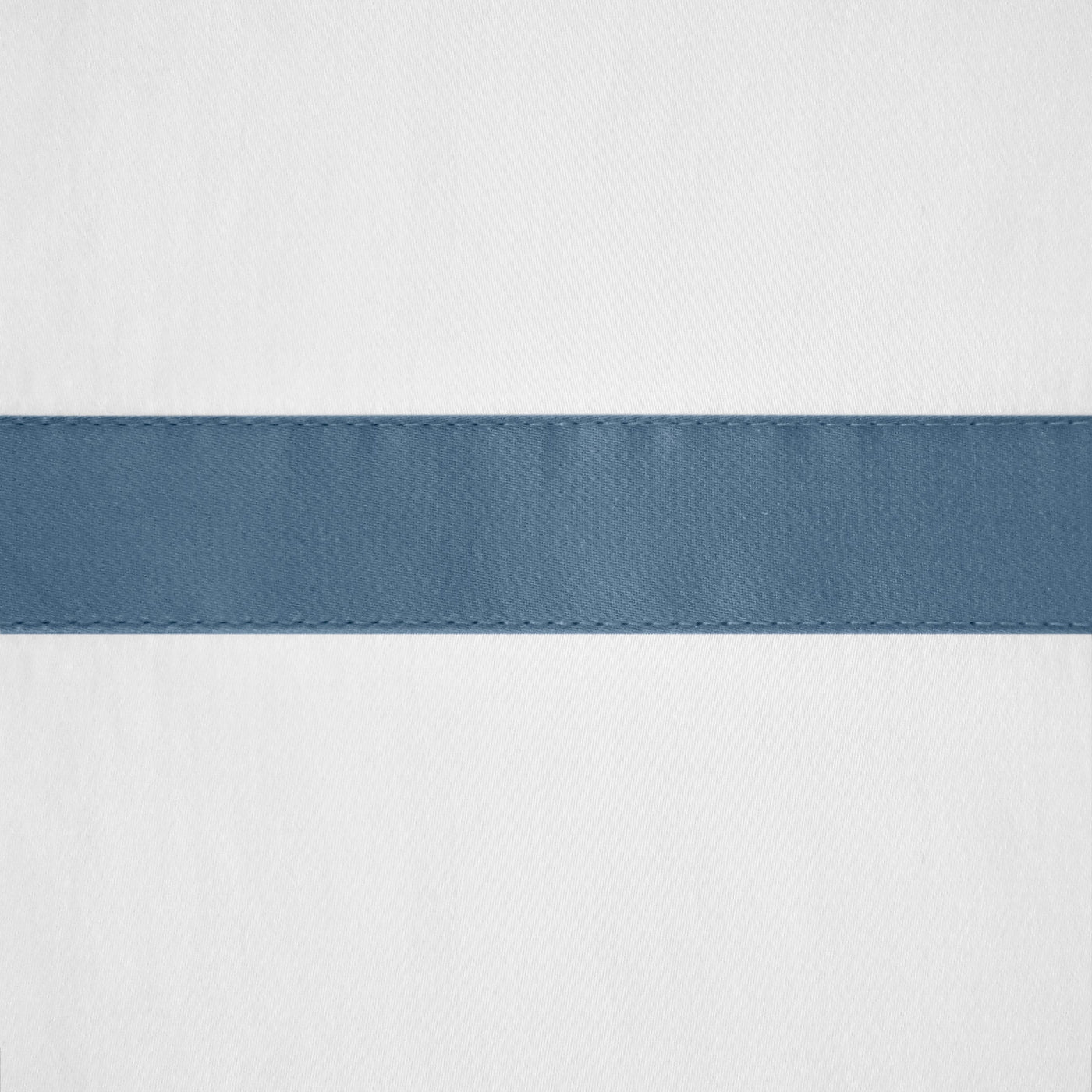 Close-up of slate blue satin border detail with topstitching on white linen.