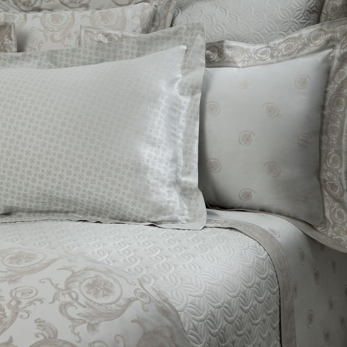 Home Treasures Firenze ivory jacquard bedding with medallion pattern on made bed.