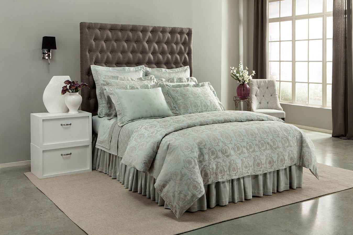 Sage green damask bedding set styled on a bed with tufted headboard in a neutral bedroom.